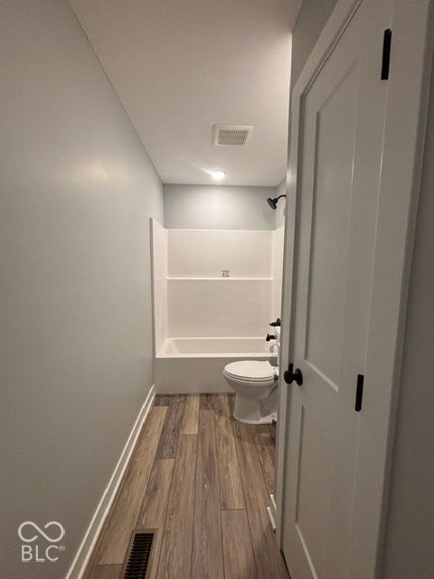 252 Indiana Street, Plainfield, IN 46168 Tub/shower combination with matte black fixtures, wood-finish flooring, and a white interior door with black hardware