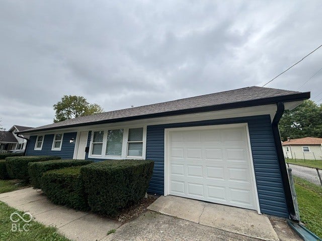 252 Indiana Street, Plainfield, IN 46168 Single-story exterior with blue horizontal siding, a dark roof, and a white paneled garage door