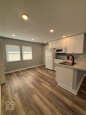 252 Indiana Street, Plainfield, IN 46168 Kitchen featuring white cabinetry, white appliances, recessed lighting, wood-finish flooring, and a peninsula with integrated sink