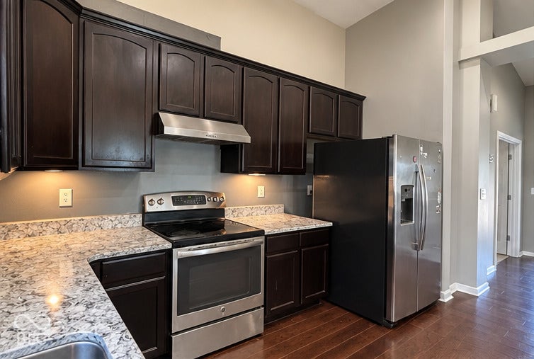 4348 Big Leaf Lane, Indianapolis, IN 46239 Kitchen featuring dark wood-finish cabinetry, granite-style countertops, stainless steel appliances, and wood-finish flooring