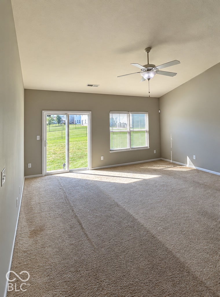 4348 Big Leaf Lane, Indianapolis, IN 46239 Carpeted living space with vaulted ceiling and ceiling fan