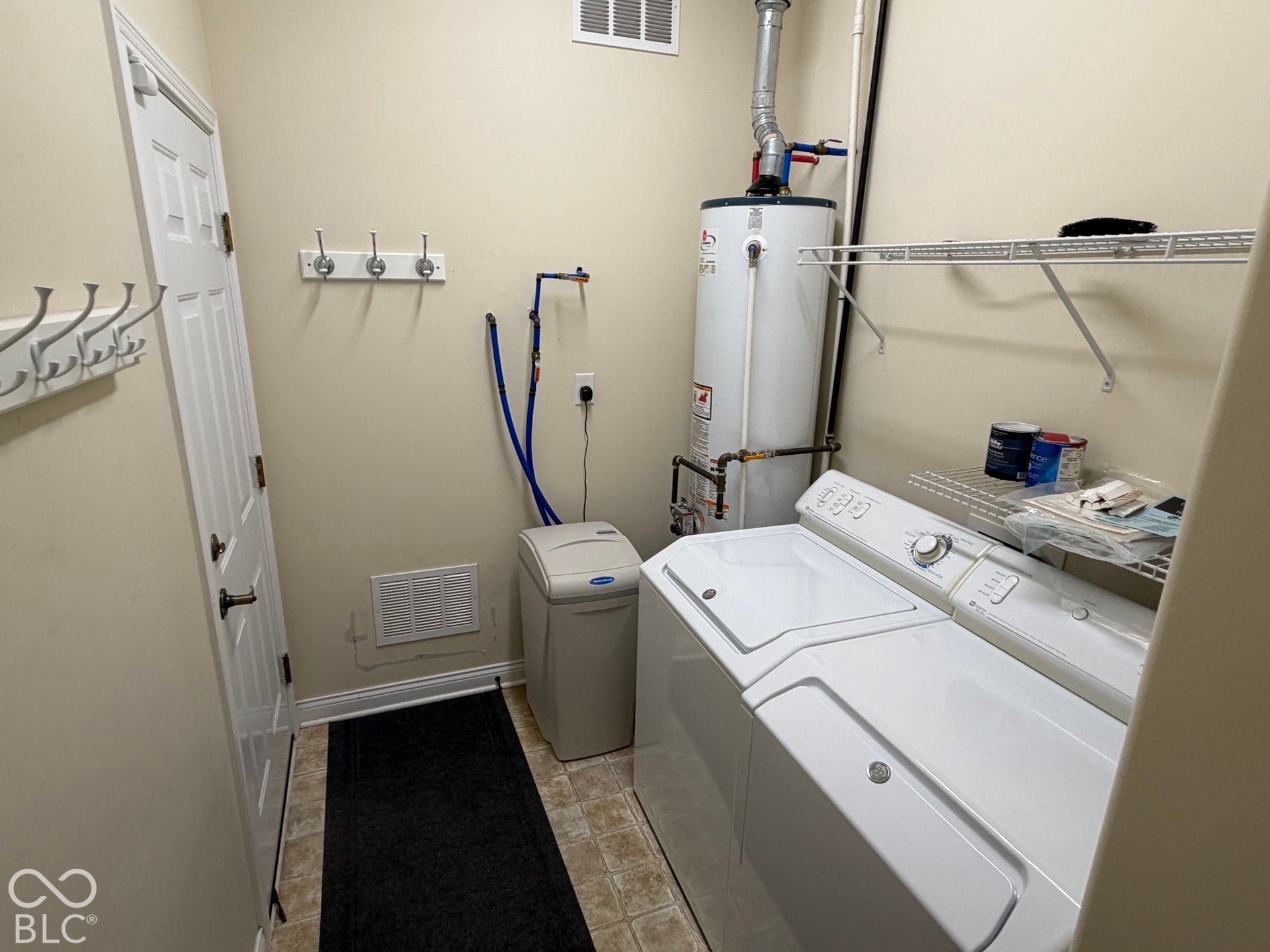 Utility area featuring a water heater, water softener system, and built-in shelving