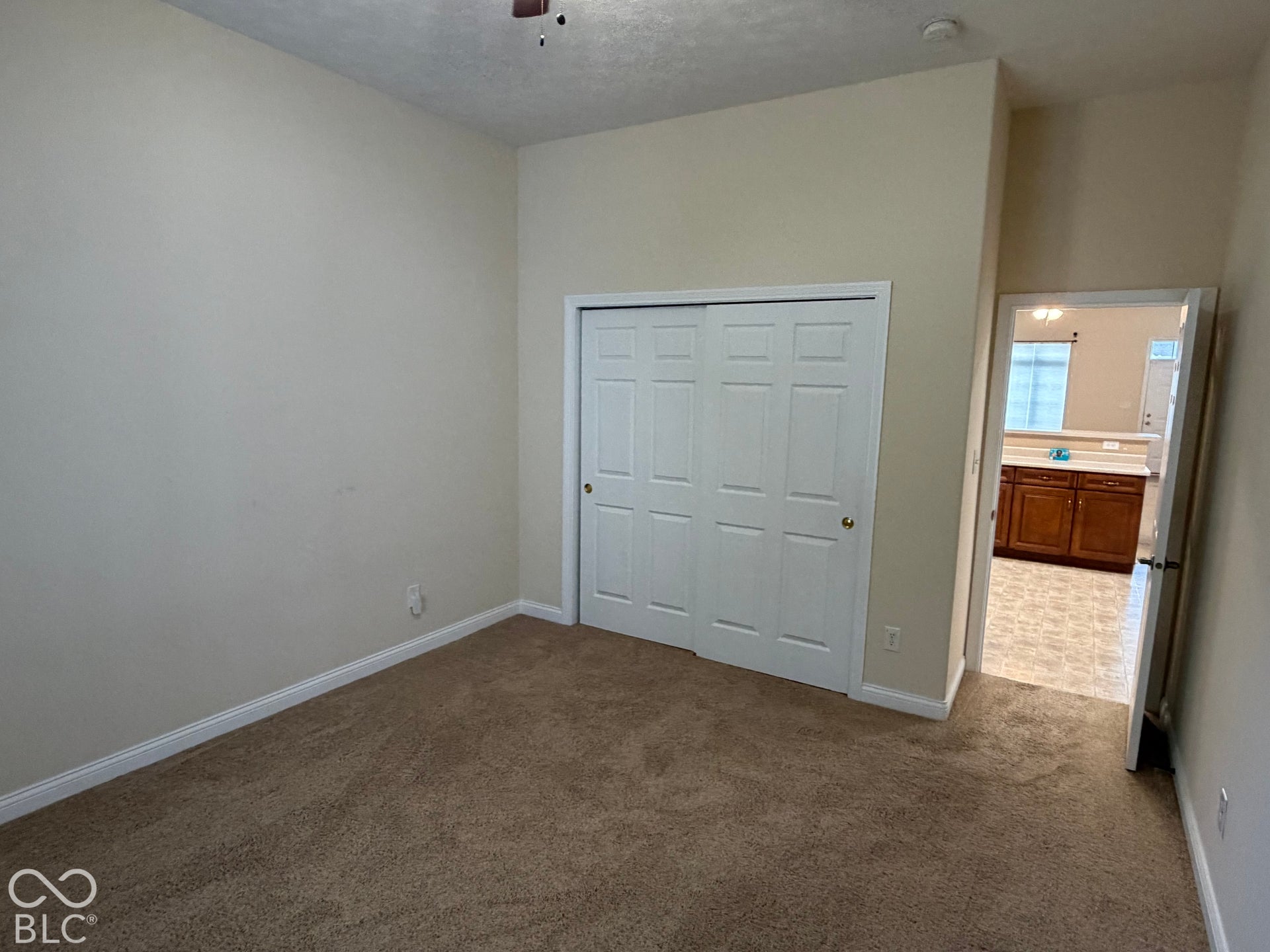Carpeted flooring, vaulted ceiling, and white bifold closet doors