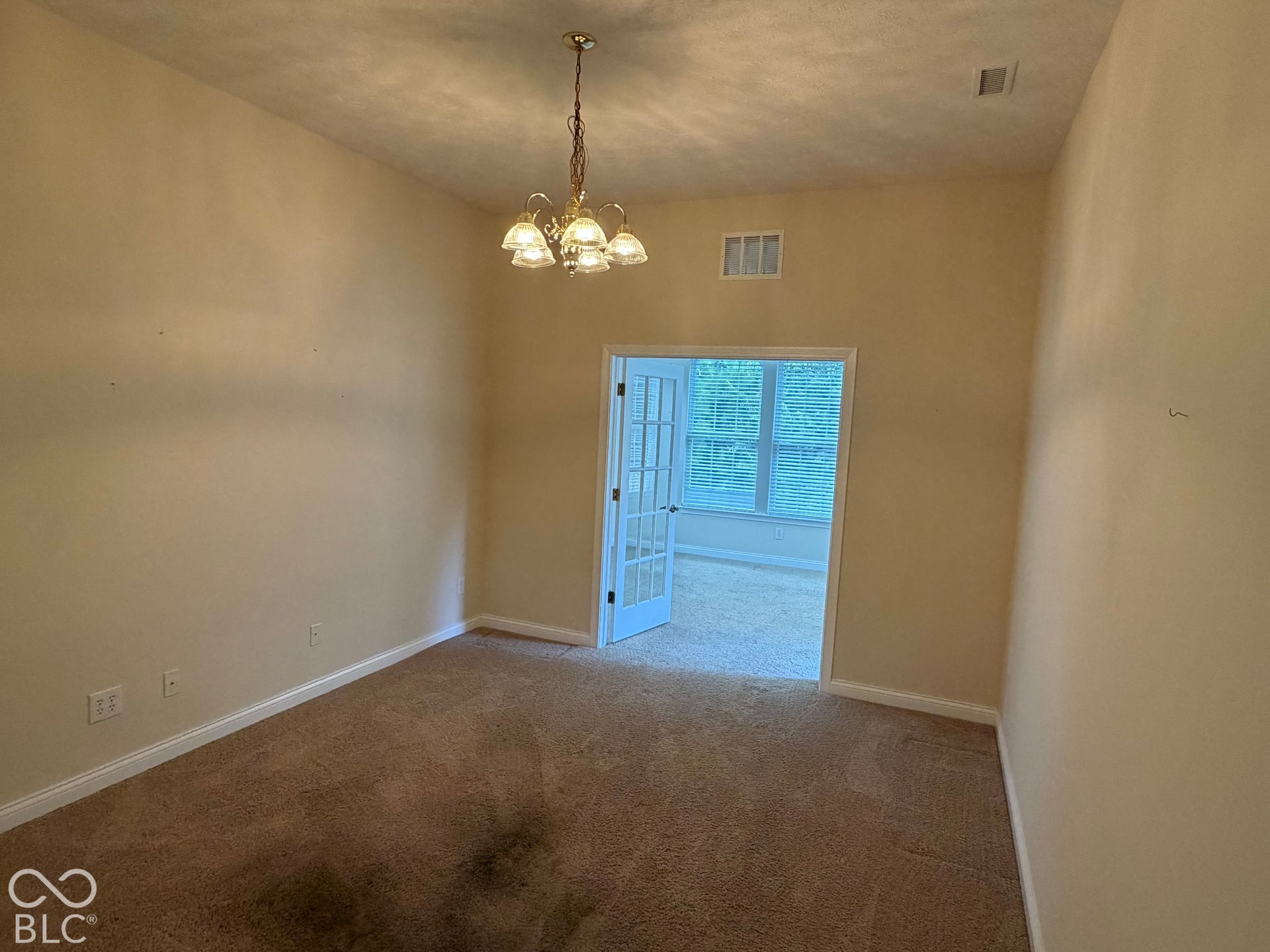 Recessed lighting, French doors, and a decorative chandelier