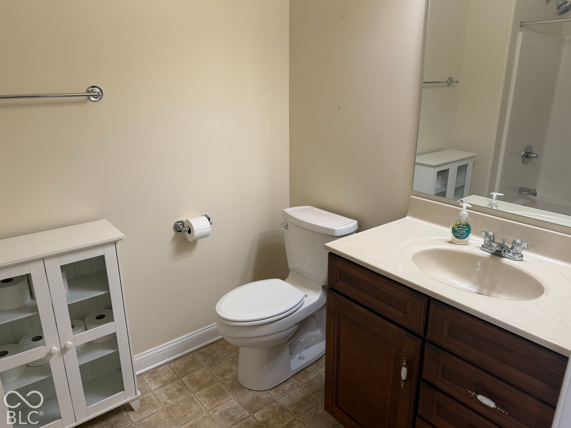 Bathroom featuring a vanity with dark wood-finish cabinetry, a light-colored countertop, and an integrated sink