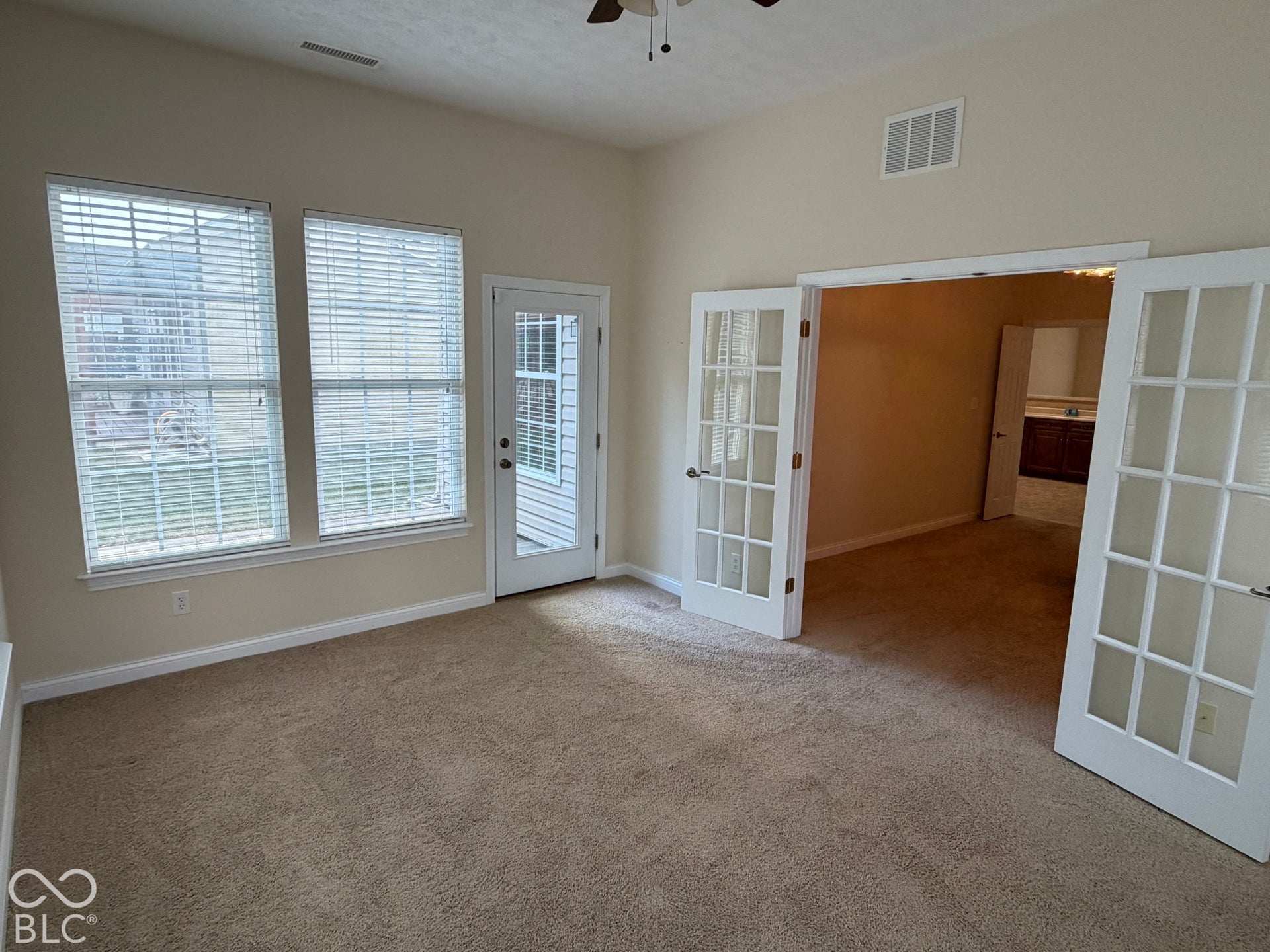 Carpeted room with vaulted ceilings and a ceiling fan
