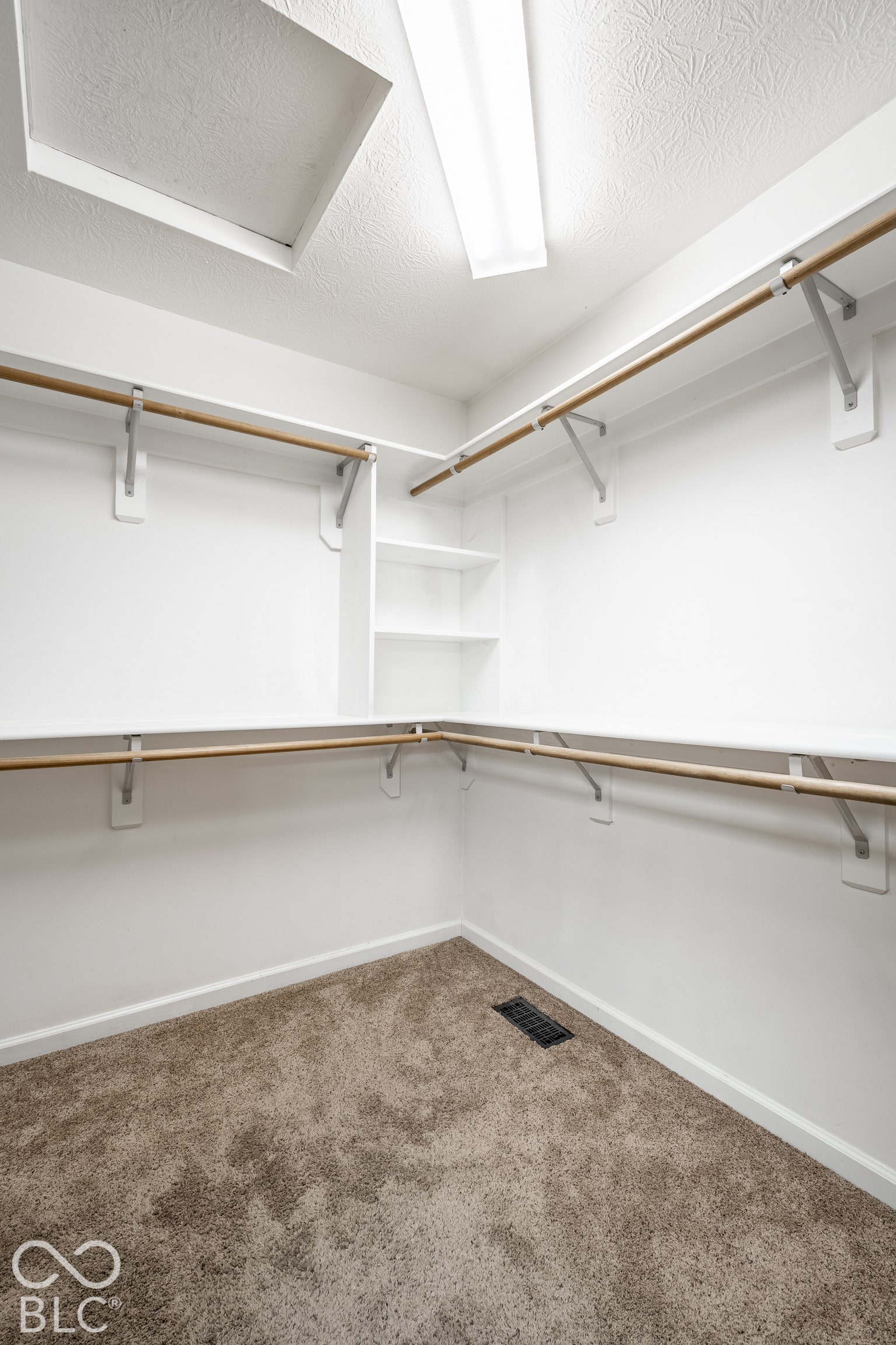 Primary suite walk-in closet with built-in shelving