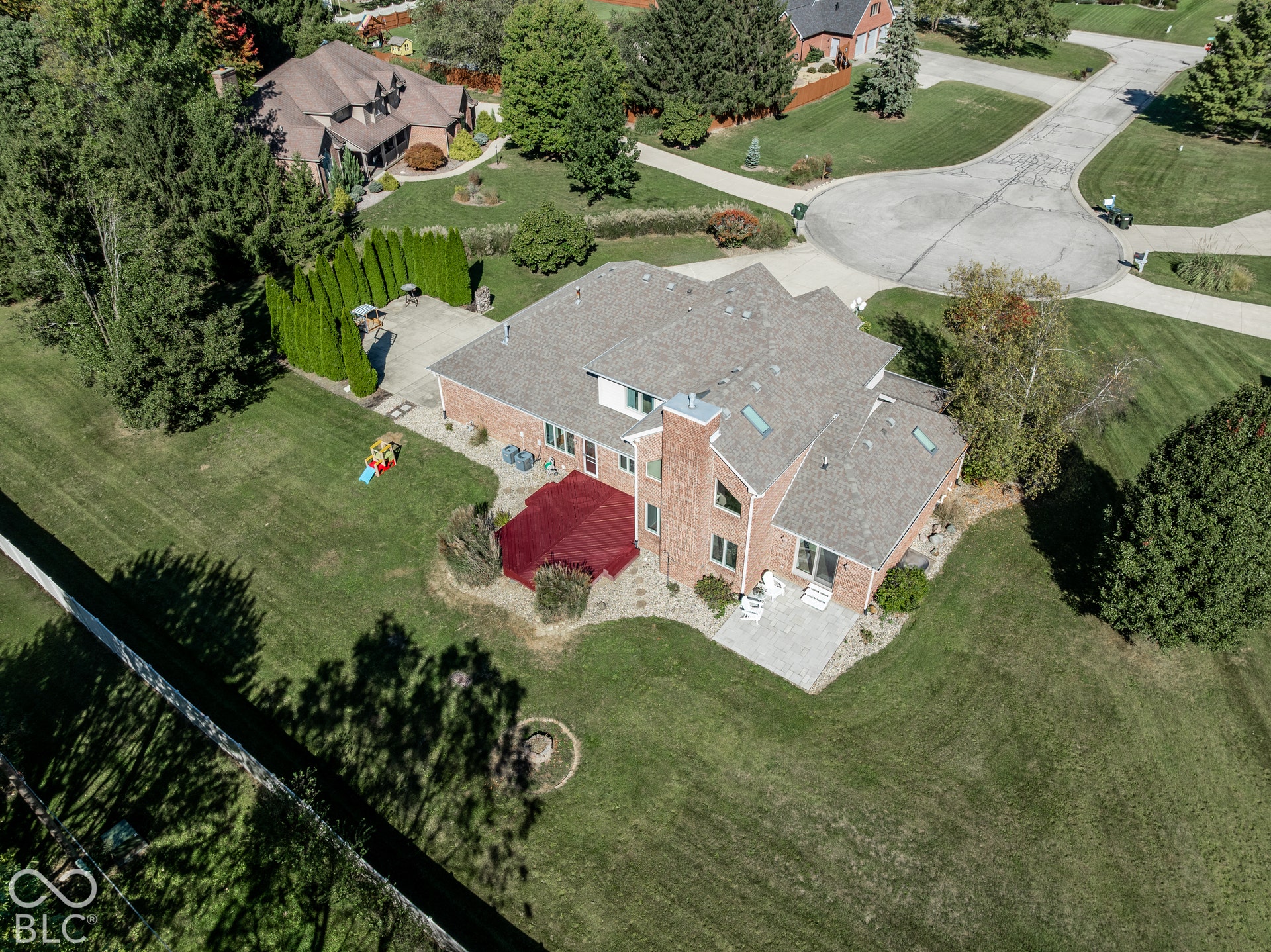 Brick exterior residence with a multi-gabled roof, multiple skylights, and a prominent chimney