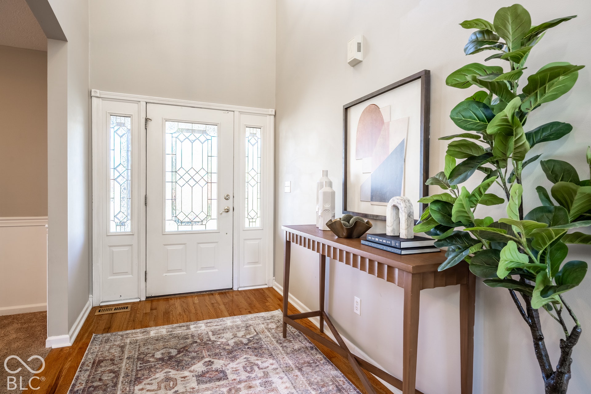 Vaulted entry with wood flooring
