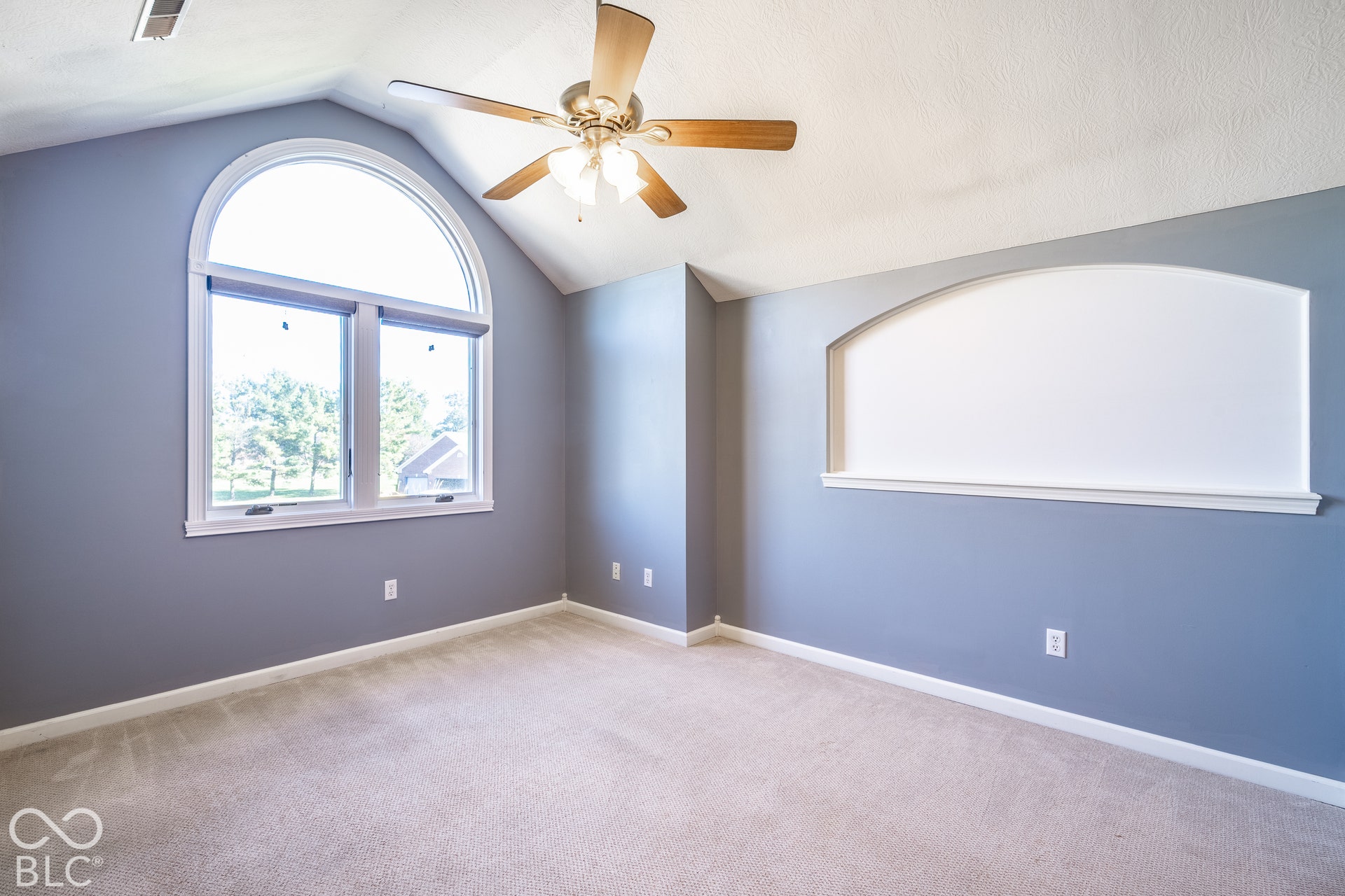 Bedroom 4 with arched window with upper transom, vaulted ceiling, ceiling fan. Could be used as home-office or bonus room