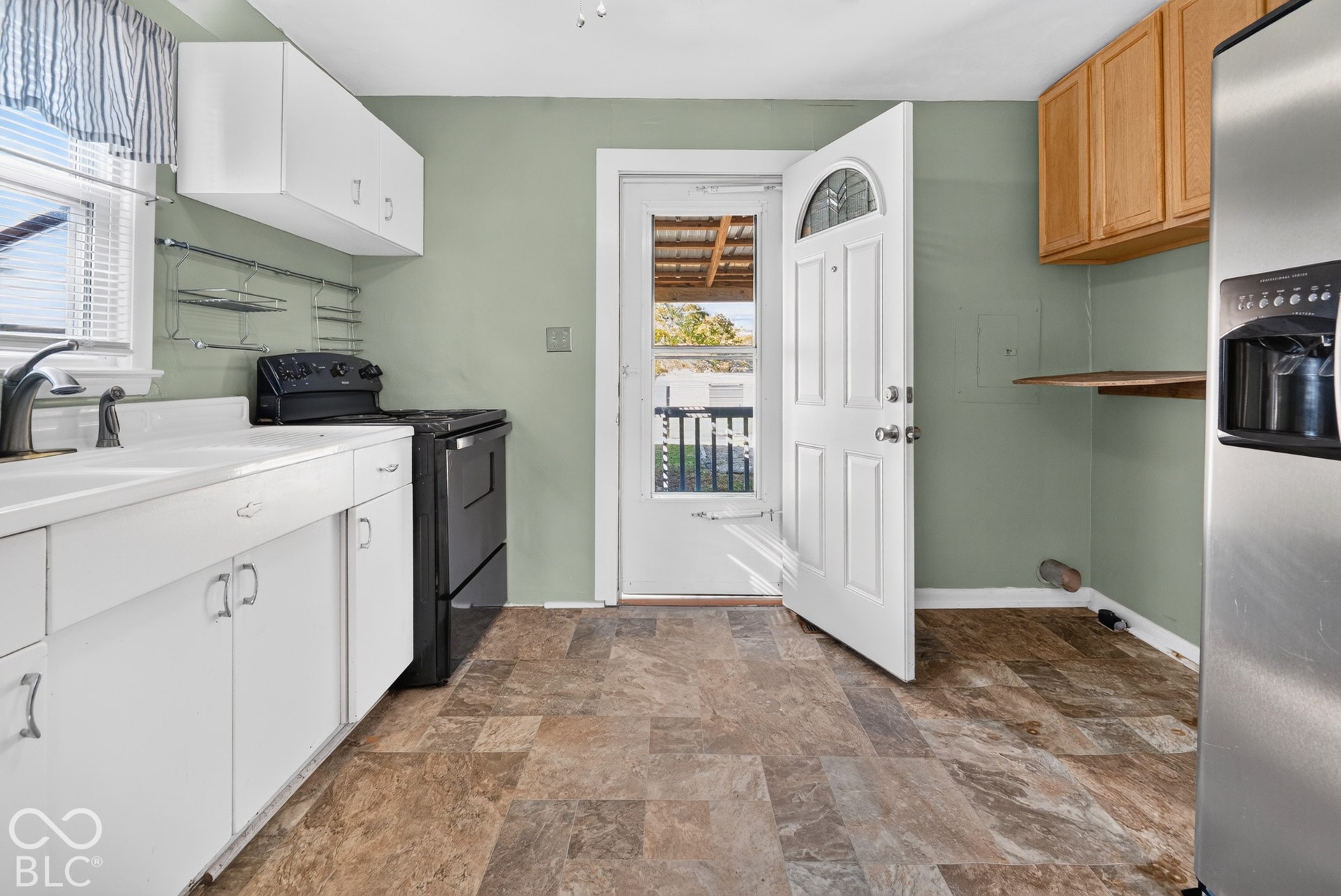 2706 13th Street, Columbus, IN 47201 Kitchen featuring white cabinetry, contrasting wood-finish wall cabinets, stainless steel appliances, and tile flooring