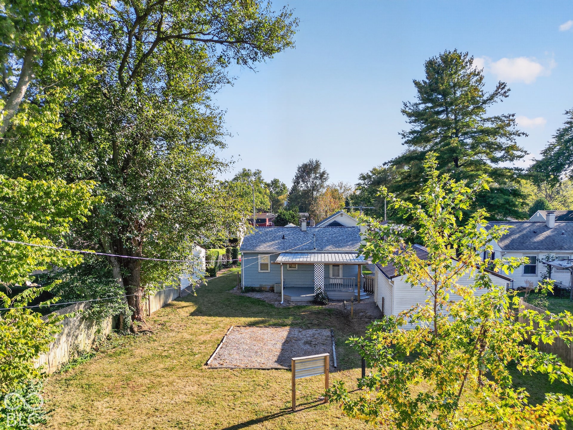 2706 13th Street, Columbus, IN 47201 Backyard featuring a covered patio, mature trees, fenced perimeter, and dedicated ground-level recreational area