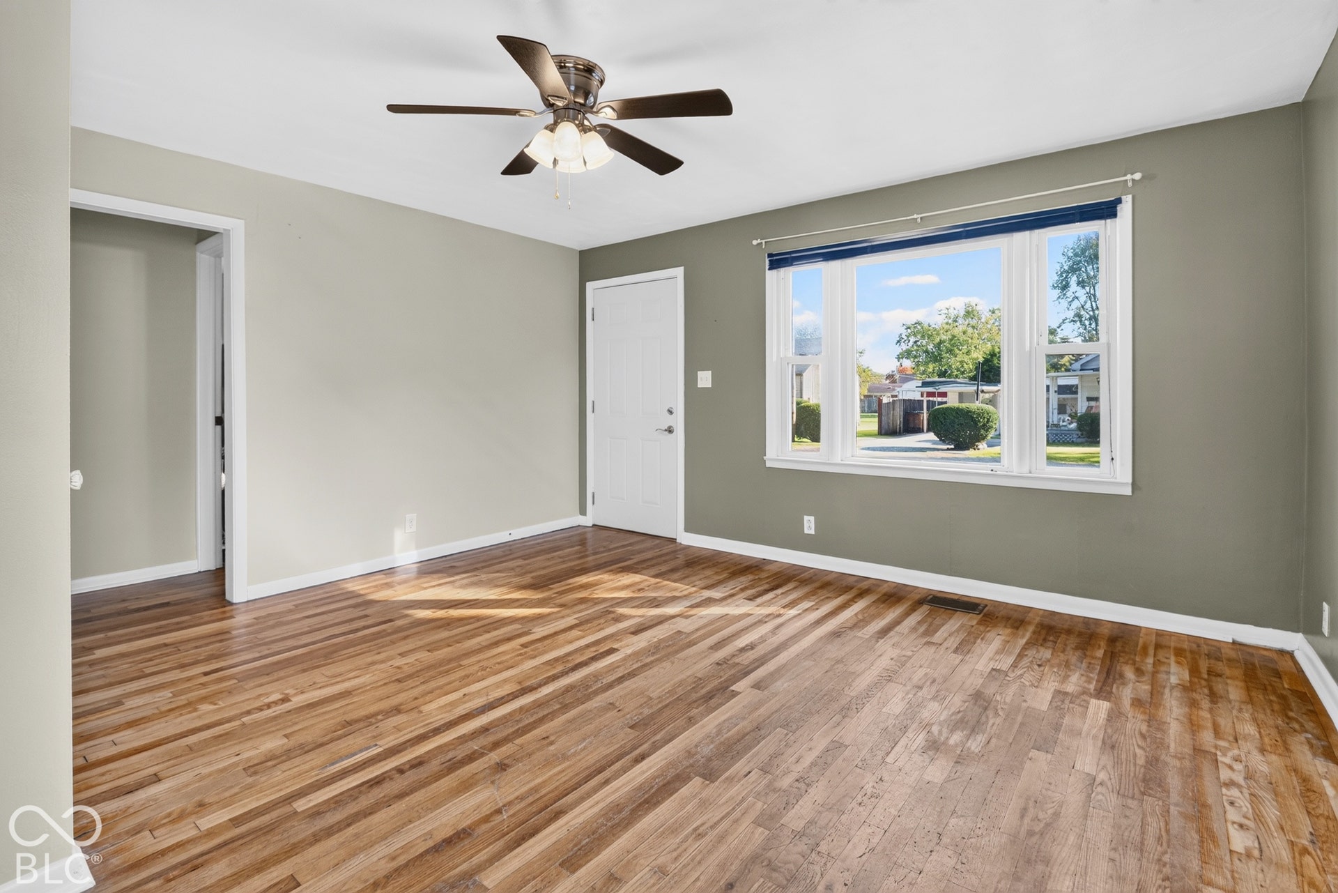 2706 13th Street, Columbus, IN 47201 Room featuring wood-finish flooring, a multi-blade ceiling fan with integrated lighting, and a picture window