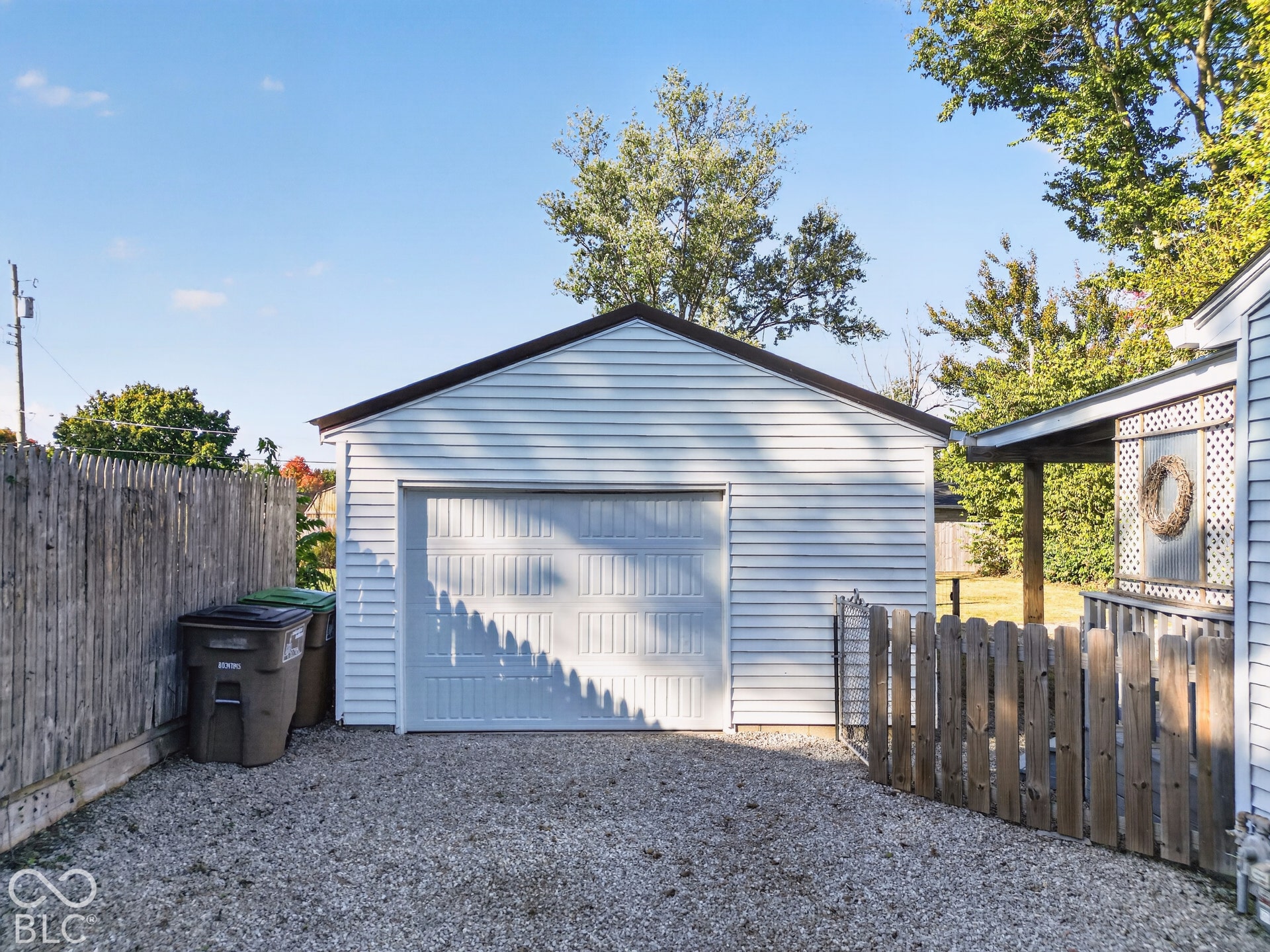 2706 13th Street, Columbus, IN 47201 Detached garage featuring white vinyl siding, a paneled sectional door, and a gravel driveway