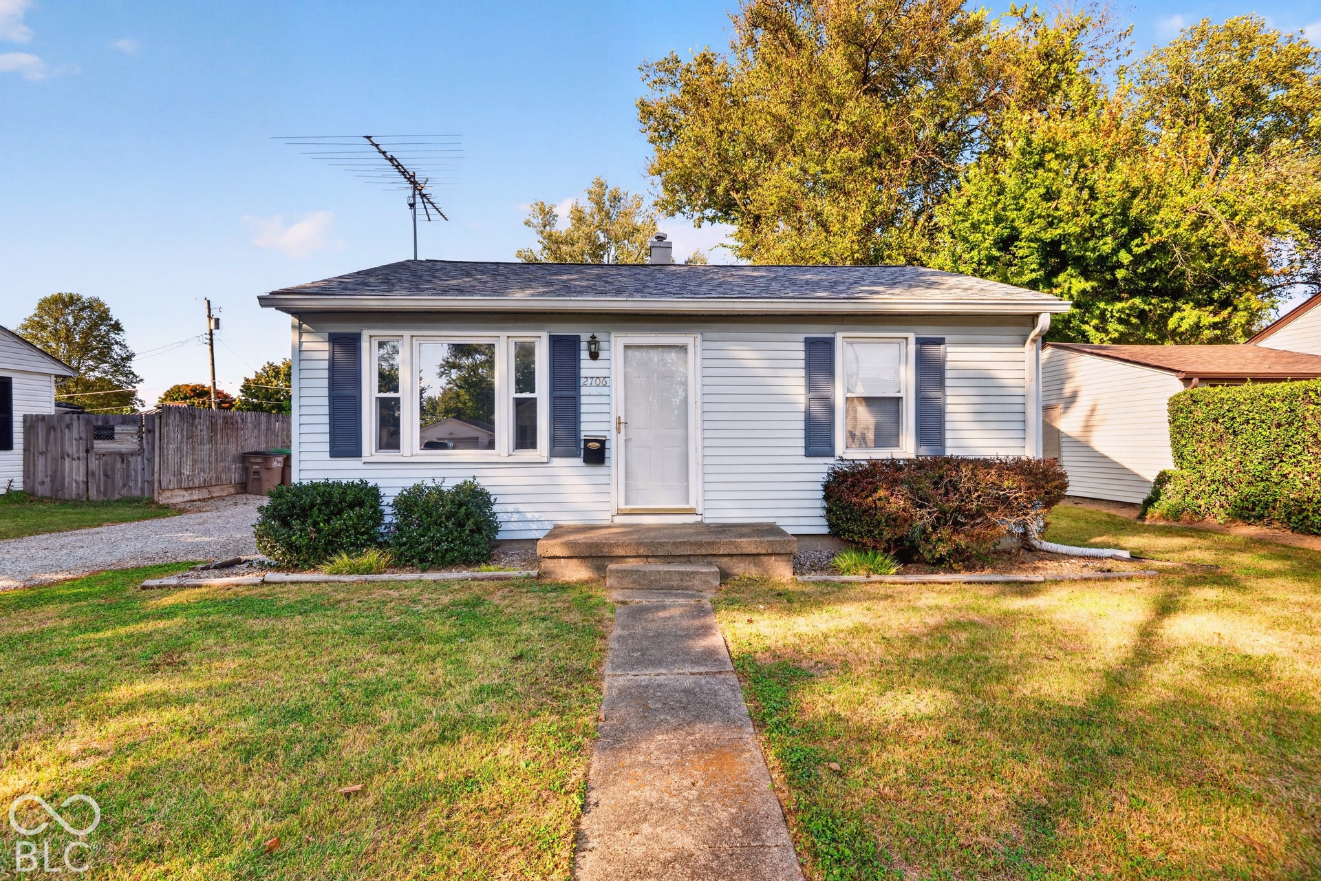 2706 13th Street, Columbus, IN 47201 Single-story residence featuring horizontal lap siding, decorative window shutters, a concrete front entry stoop, and a concrete walkway