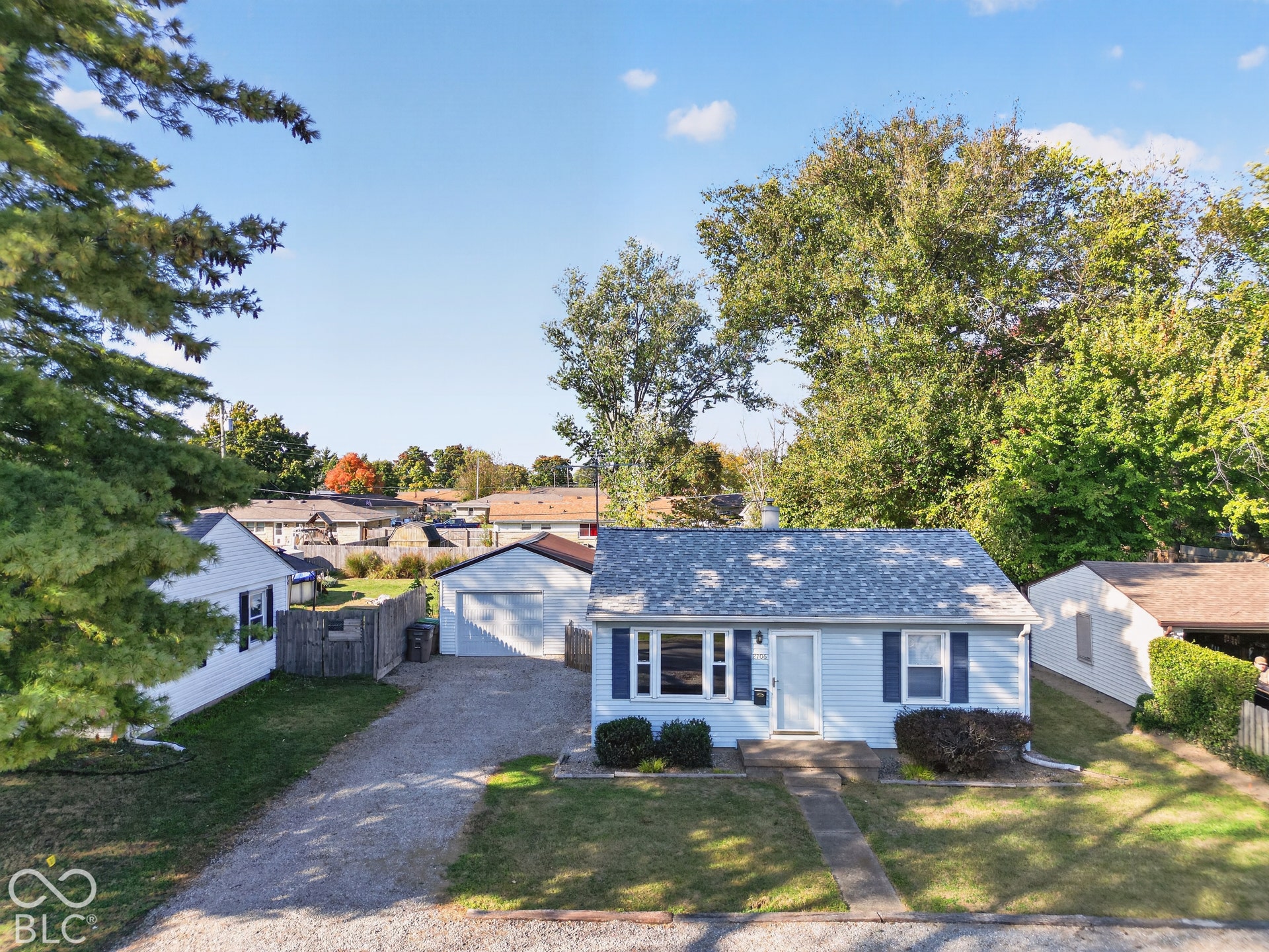 2706 13th Street, Columbus, IN 47201 Light blue exterior siding, asphalt shingle roofing, detached single-car garage, and gravel driveway