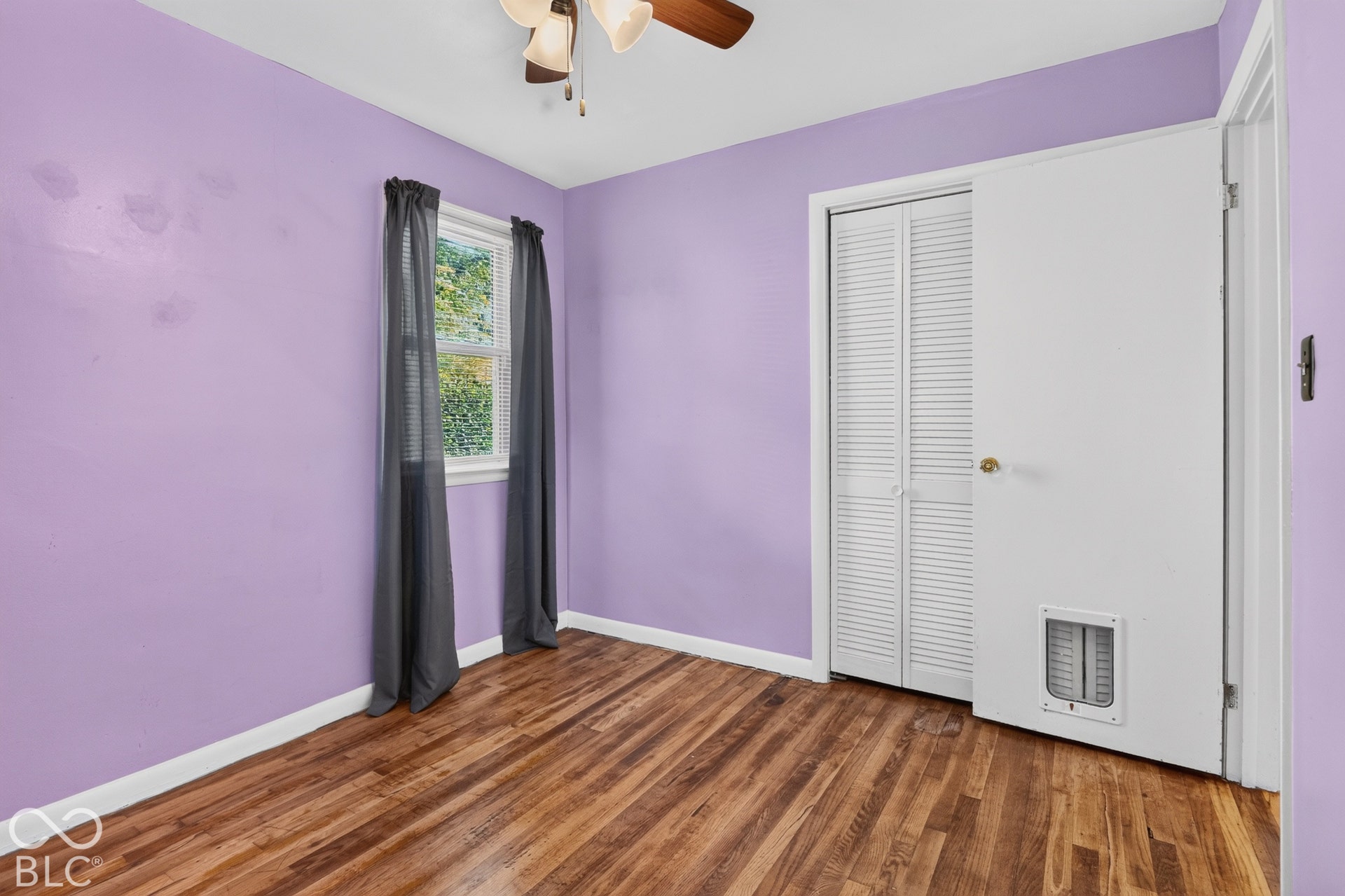 2706 13th Street, Columbus, IN 47201 Wood-finish flooring, white louvered-style closet doors, and ceiling-mounted light fixture with fan
