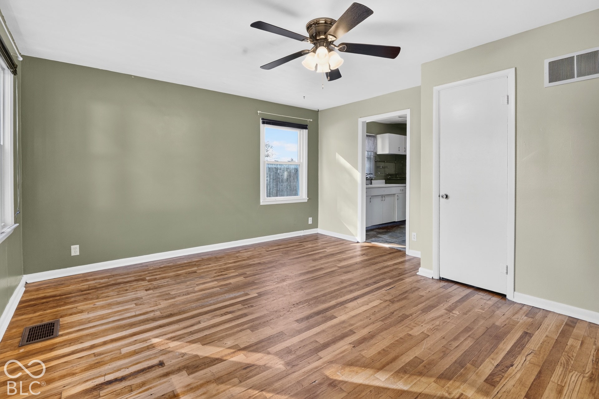 2706 13th Street, Columbus, IN 47201 Interior room featuring wood-finish flooring, a multi-blade ceiling fan with integrated lighting, and a single-panel interior door