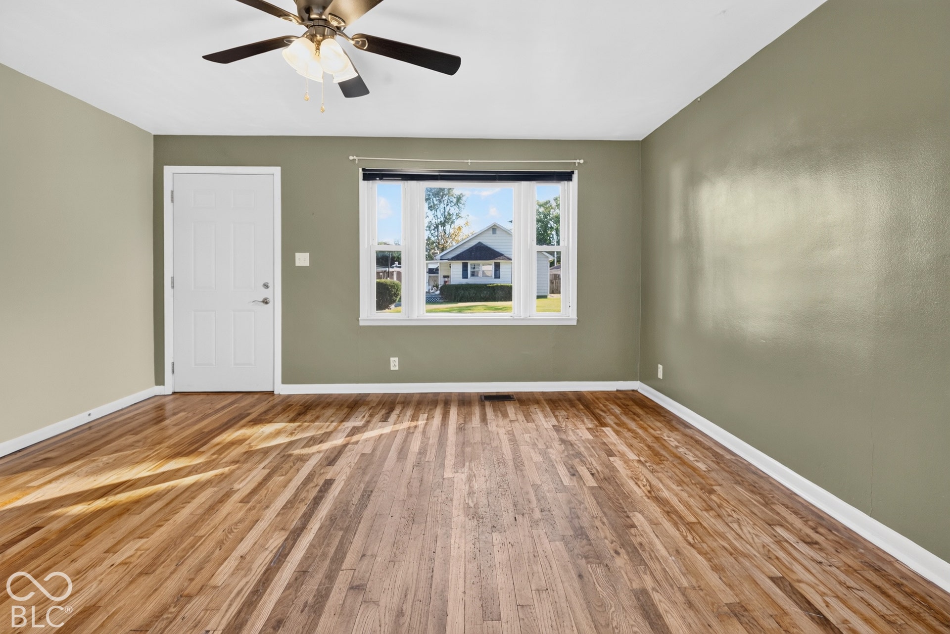 2706 13th Street, Columbus, IN 47201 Room featuring wood-finish flooring, a large picture window, and a ceiling fan with integrated lighting