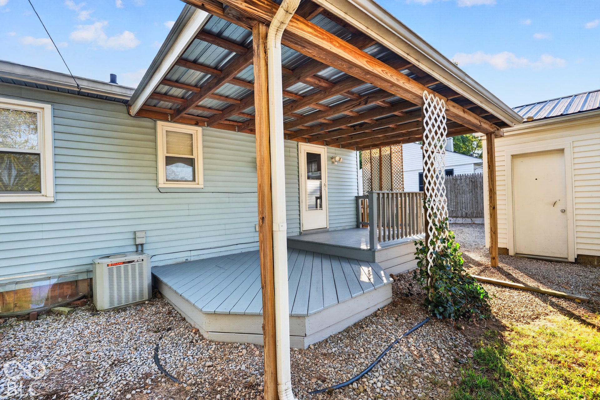 2706 13th Street, Columbus, IN 47201 Covered wooden deck featuring a multi-level design, attached lattice screen, and timber support posts