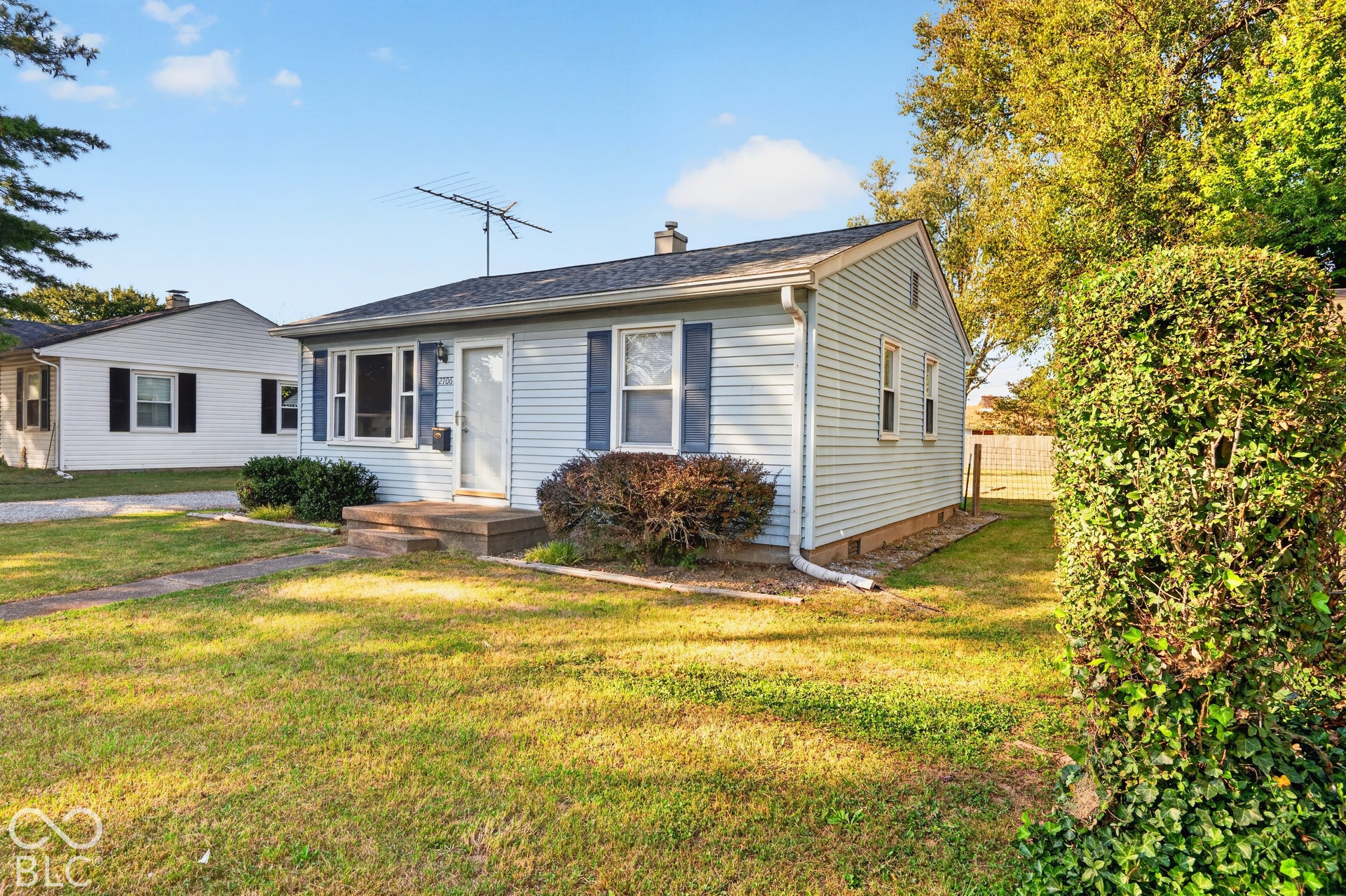 2706 13th Street, Columbus, IN 47201 Single-story residence featuring light blue horizontal siding, dark blue window shutters, a front concrete stoop, and a gabled roof