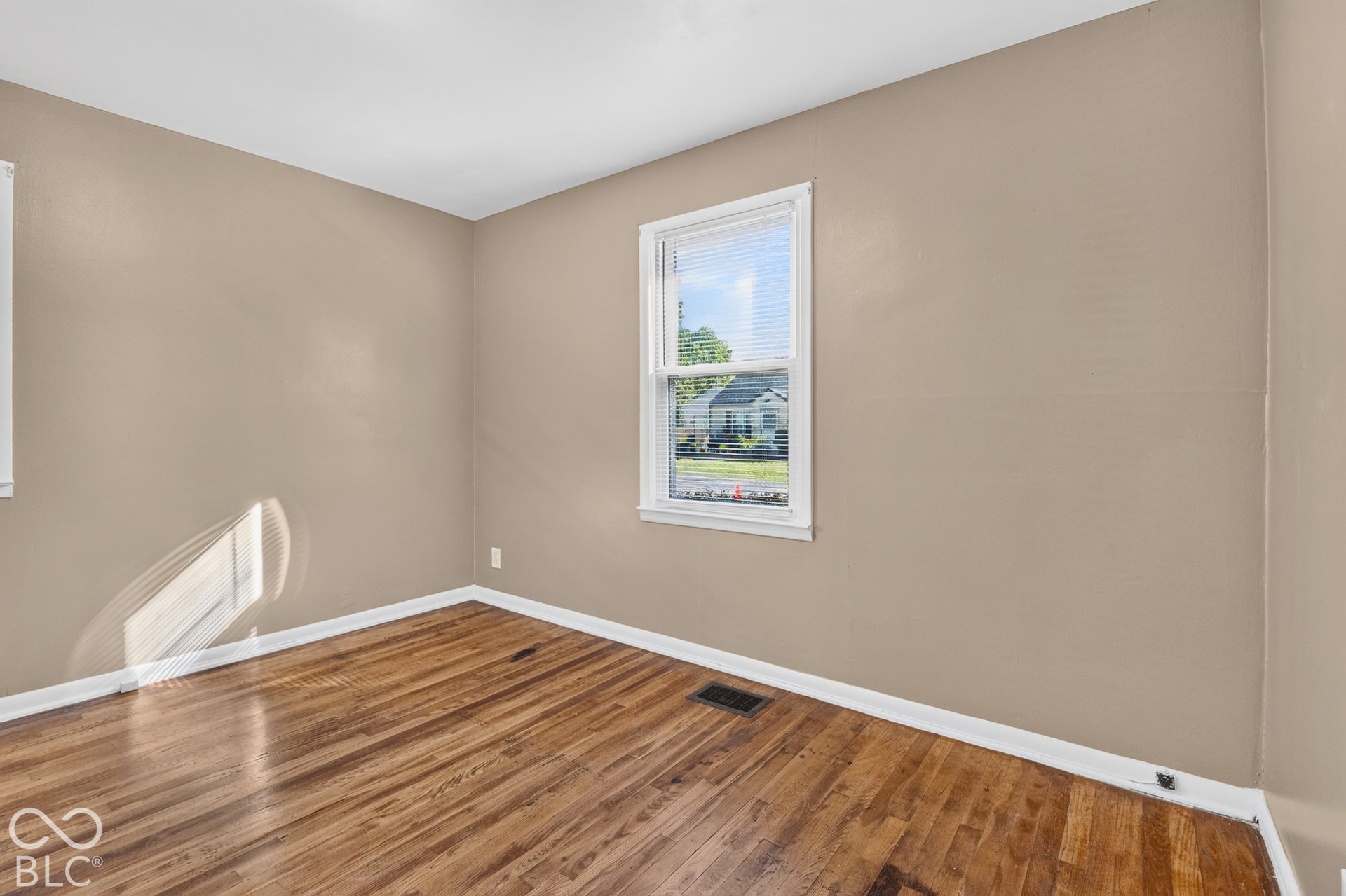 2706 13th Street, Columbus, IN 47201 Interior space featuring wood-finish flooring and a single-hung window with white casing