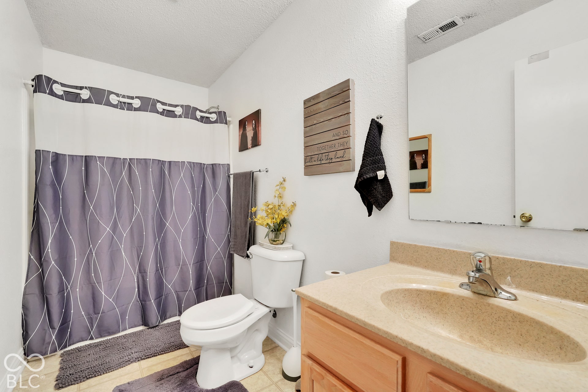 Single vanity with a light-toned countertop and integrated sink