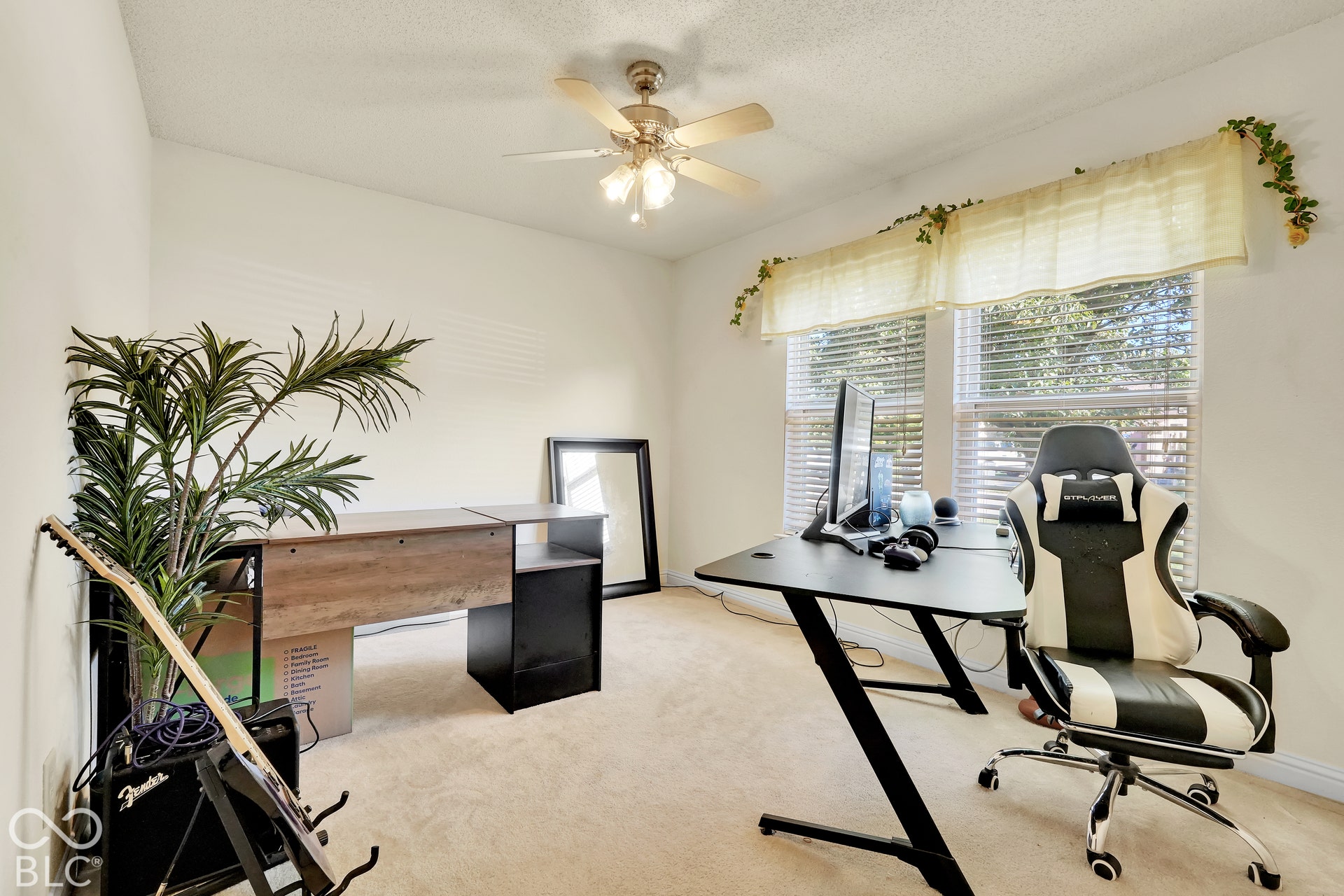 Vaulted ceiling with a ceiling fan, two windows with blinds, and neutral carpet flooring