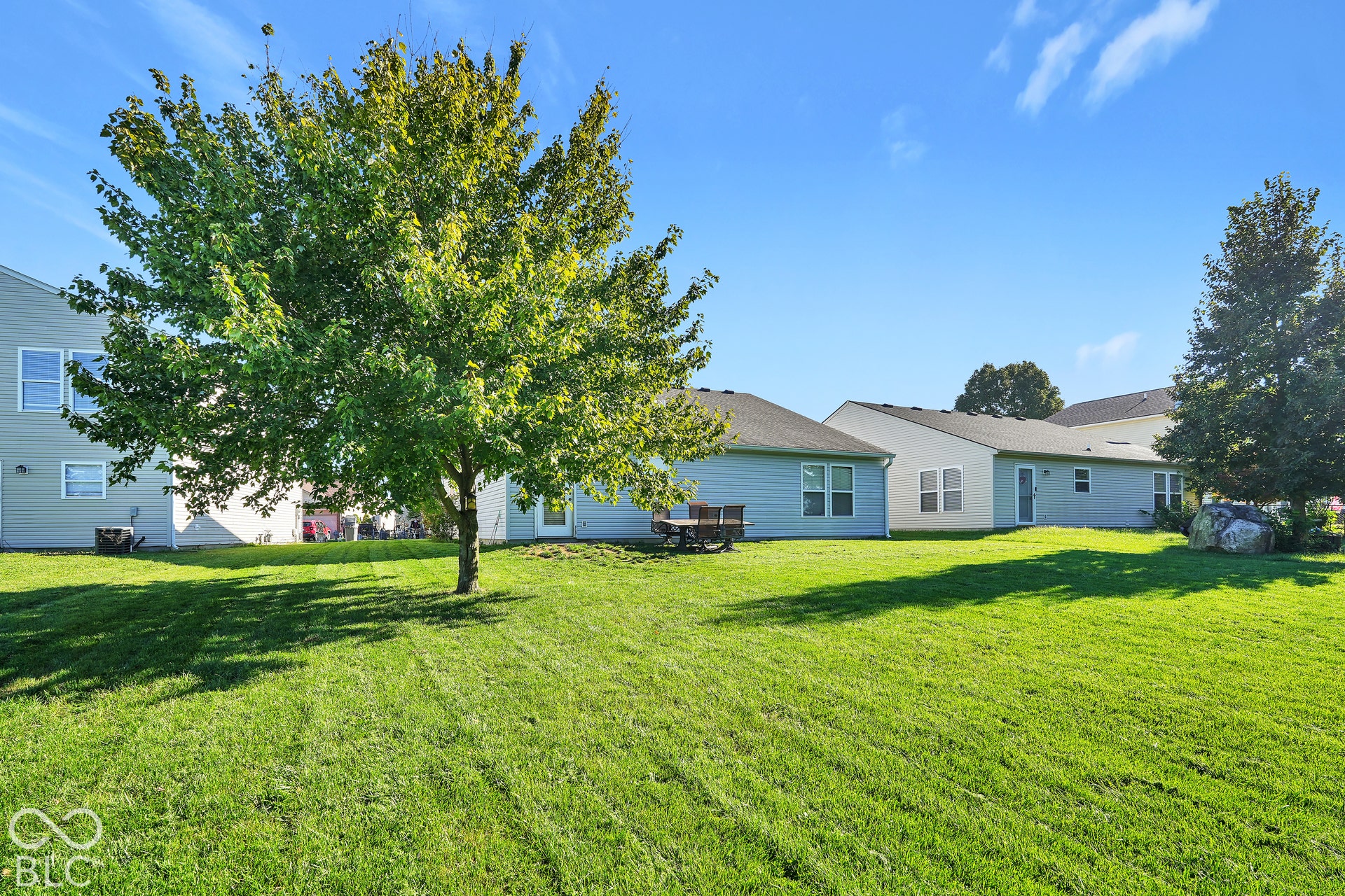 Expansive grassy yard with mature trees