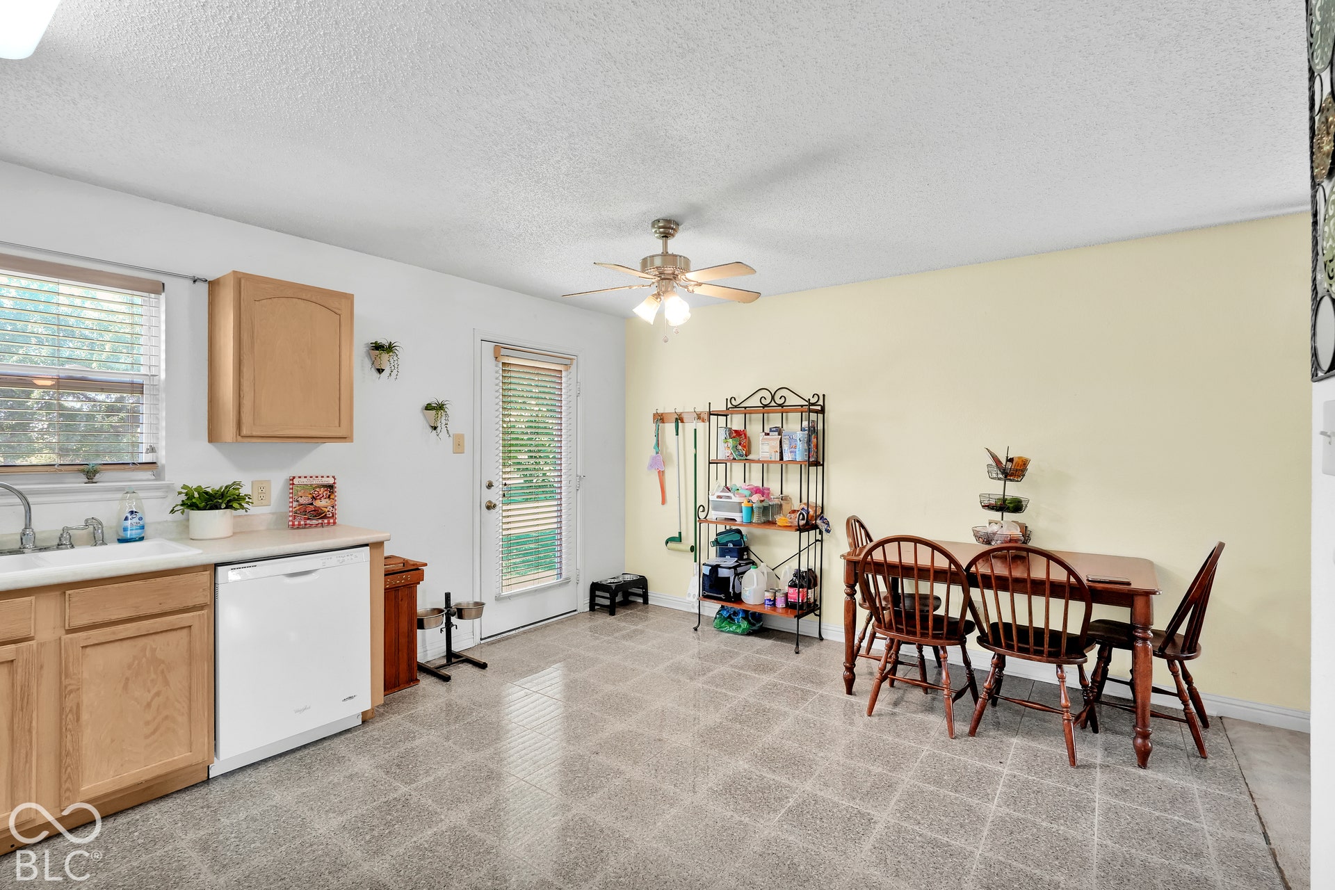 Kitchen with wood-finish cabinetry, white dishwasher, and a ceiling fan