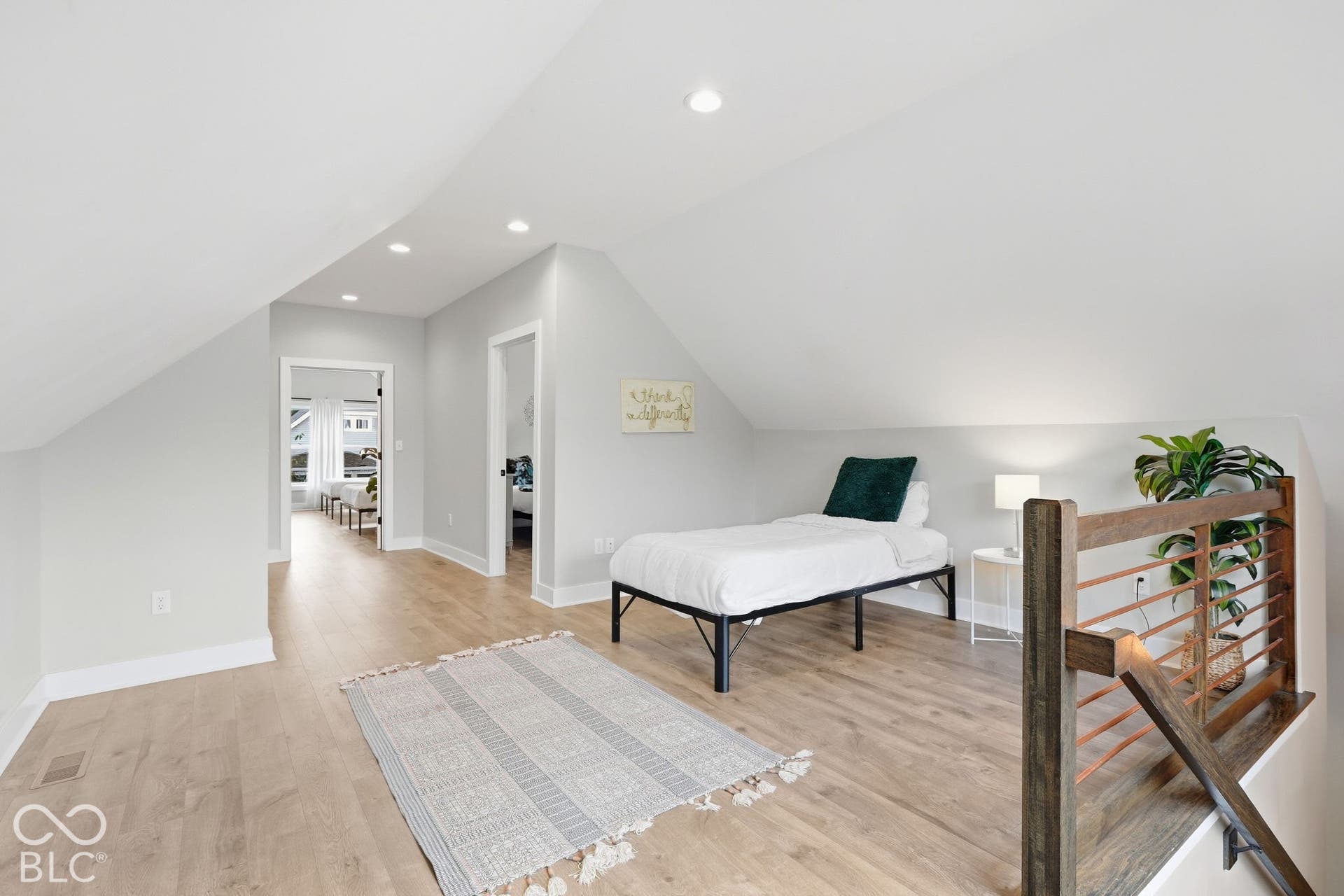 Loft area featuring wood-finish flooring, recessed lighting, a modern wood and metal railing, and sloped ceilings