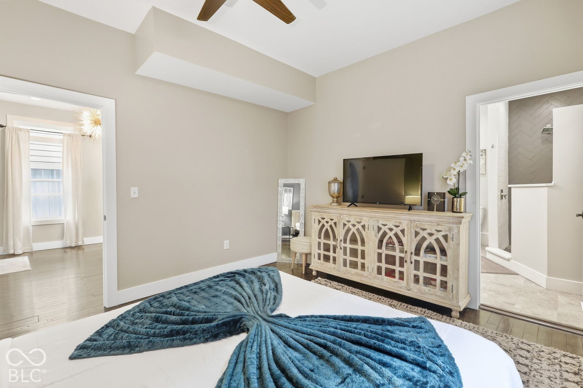 Wood-finish flooring throughout, with a decorative ceiling fan and recessed lighting