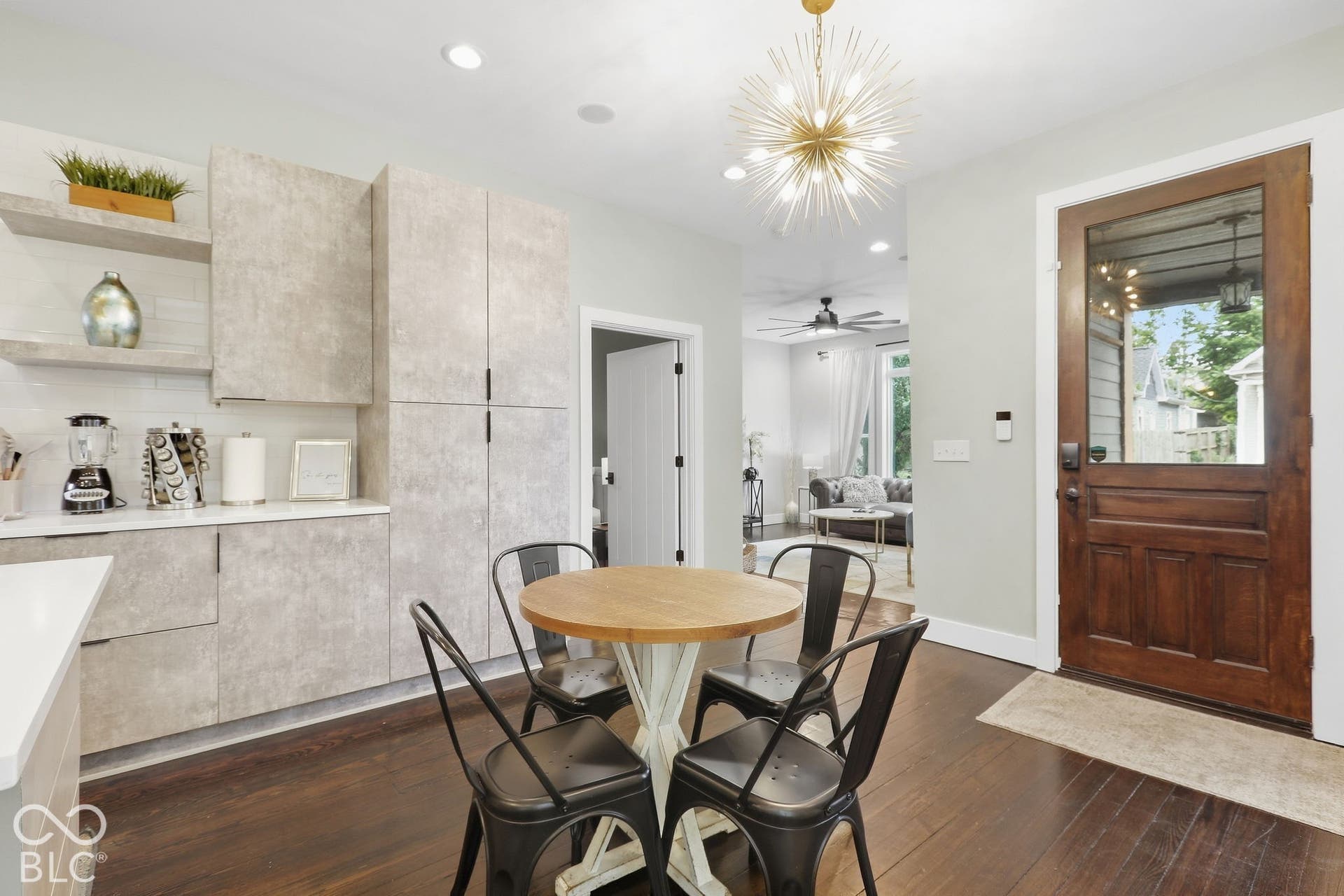 Hardwood-style flooring, a decorative sputnik chandelier, and a wood entry door with clear glass paneling