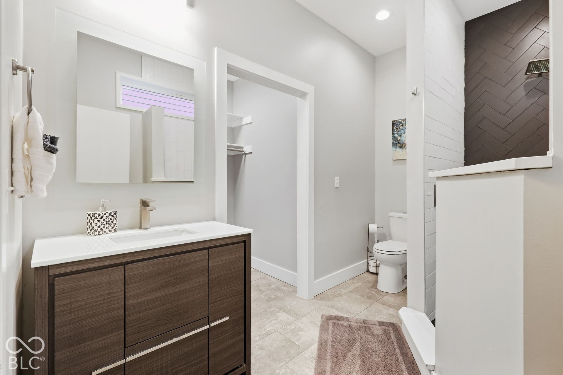 Vanity with wood-finish cabinetry, integrated sink, and brushed nickel faucet