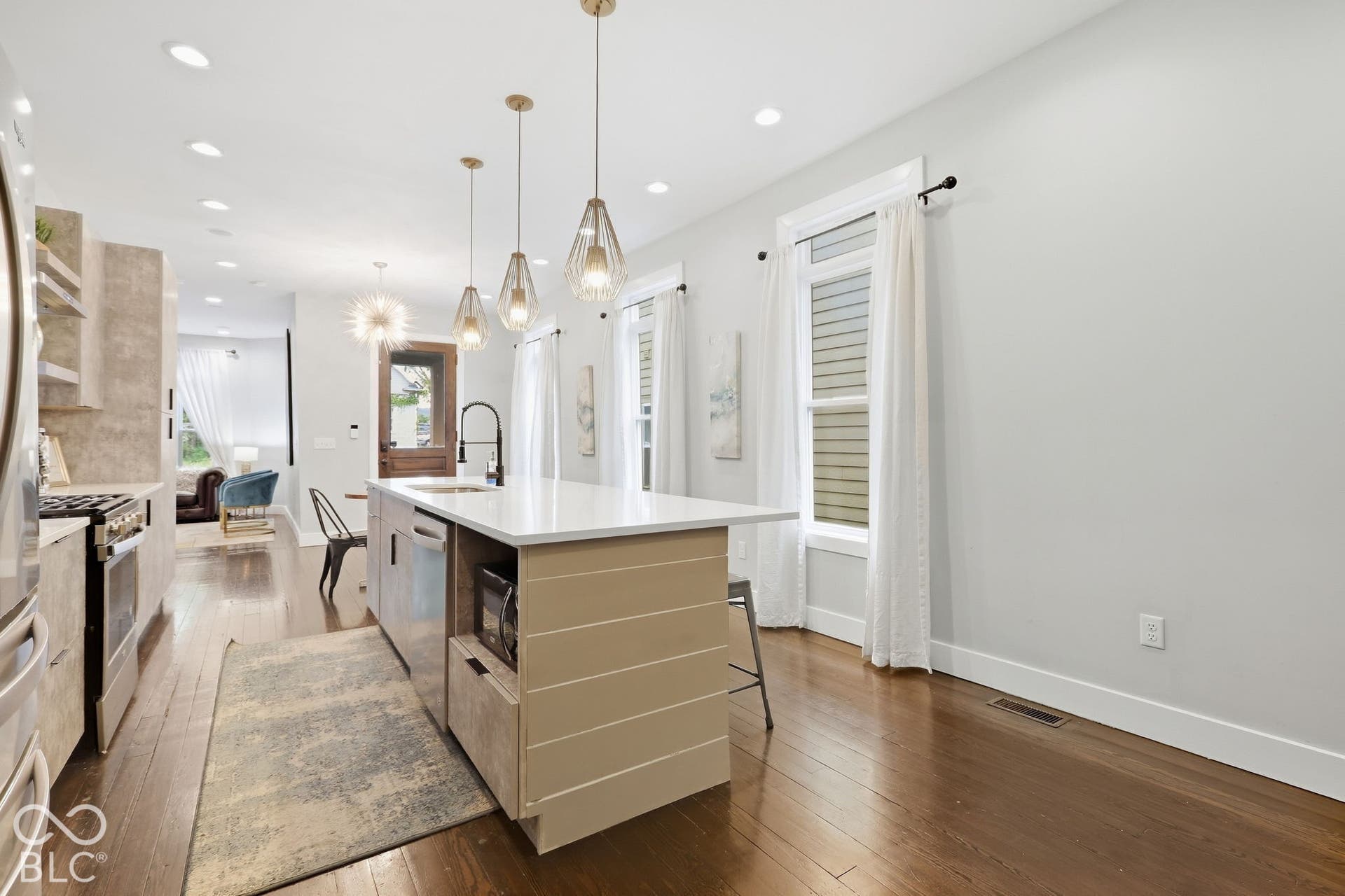 Gourmet kitchen with a center island, recessed lighting, and dark wood-finish flooring