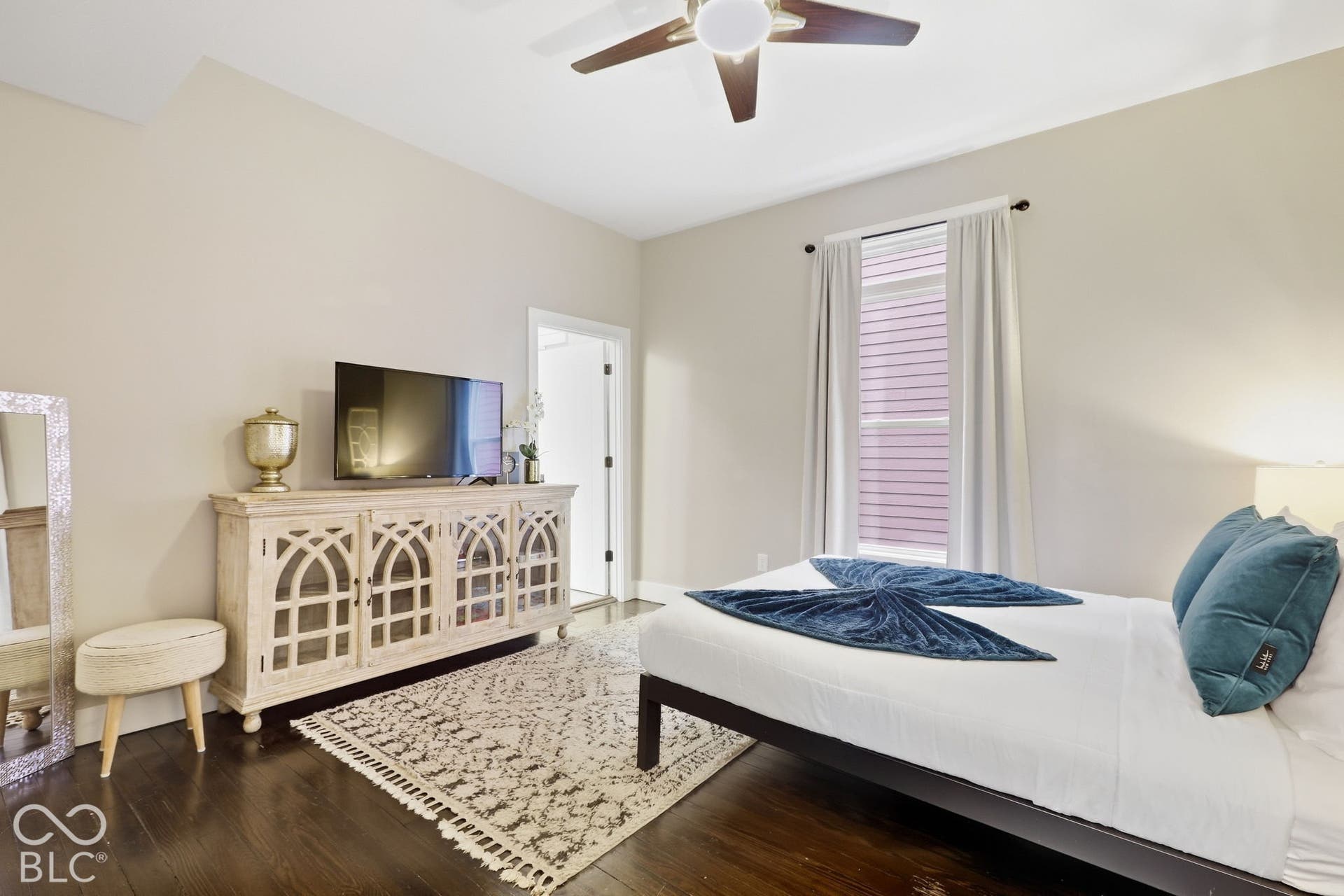Wood-finish flooring, ceiling fan with integrated lighting, single window with blinds, and neutral wall paint