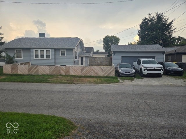 Light blue siding, multi-pane windows, and a detached garage with a single door