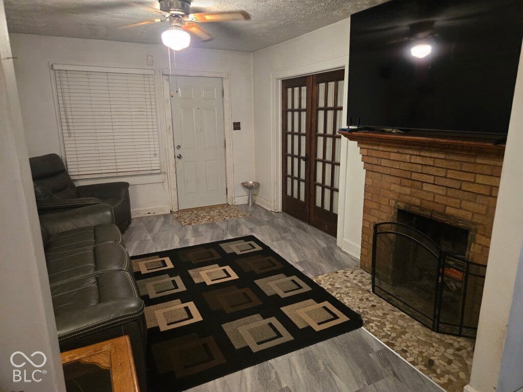 Brick fireplace with a stone hearth, wood mantle, and metal screen