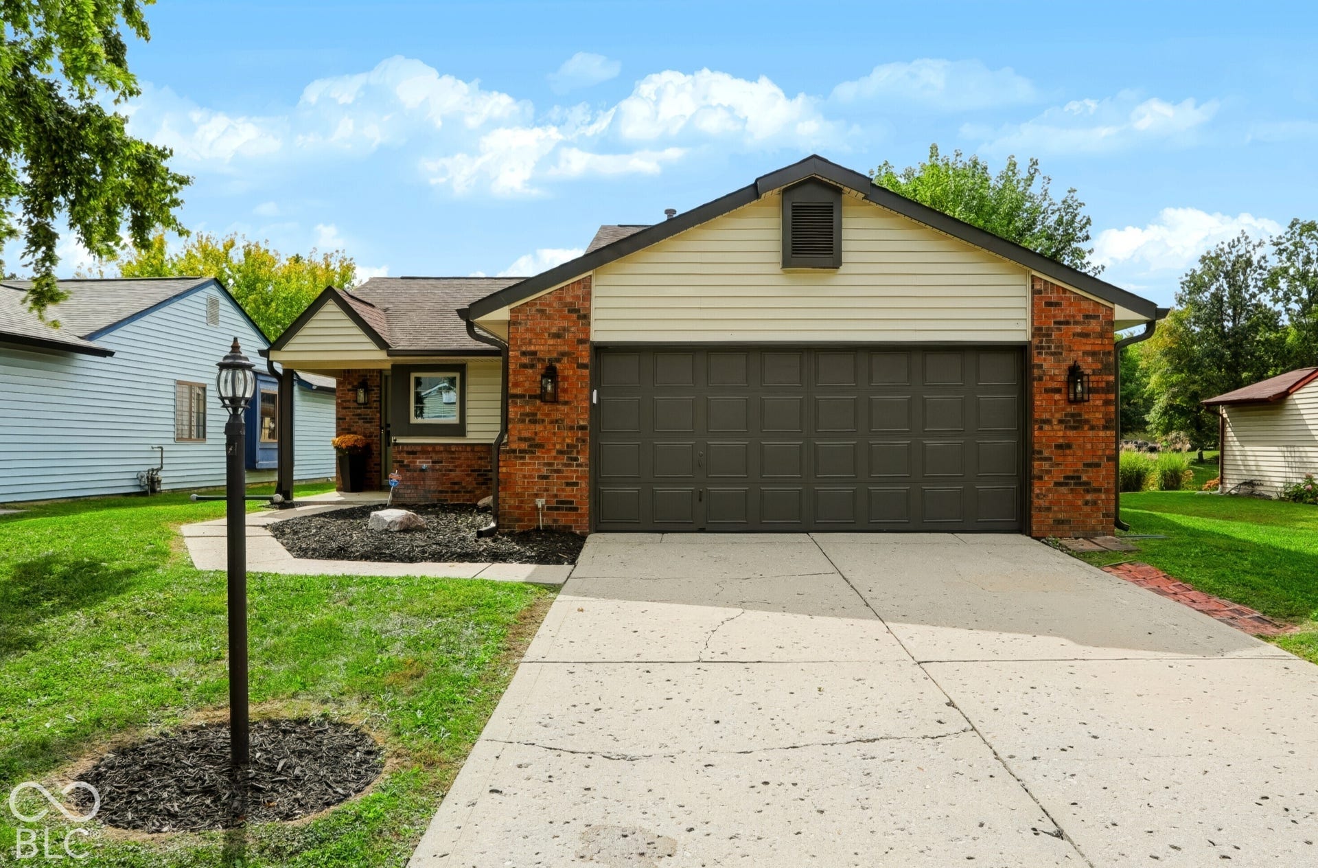 5907 Timber Lake Boulevard, Indianapolis, IN 46237 Brick and siding exterior with a dark garage door, concrete driveway, and covered entry