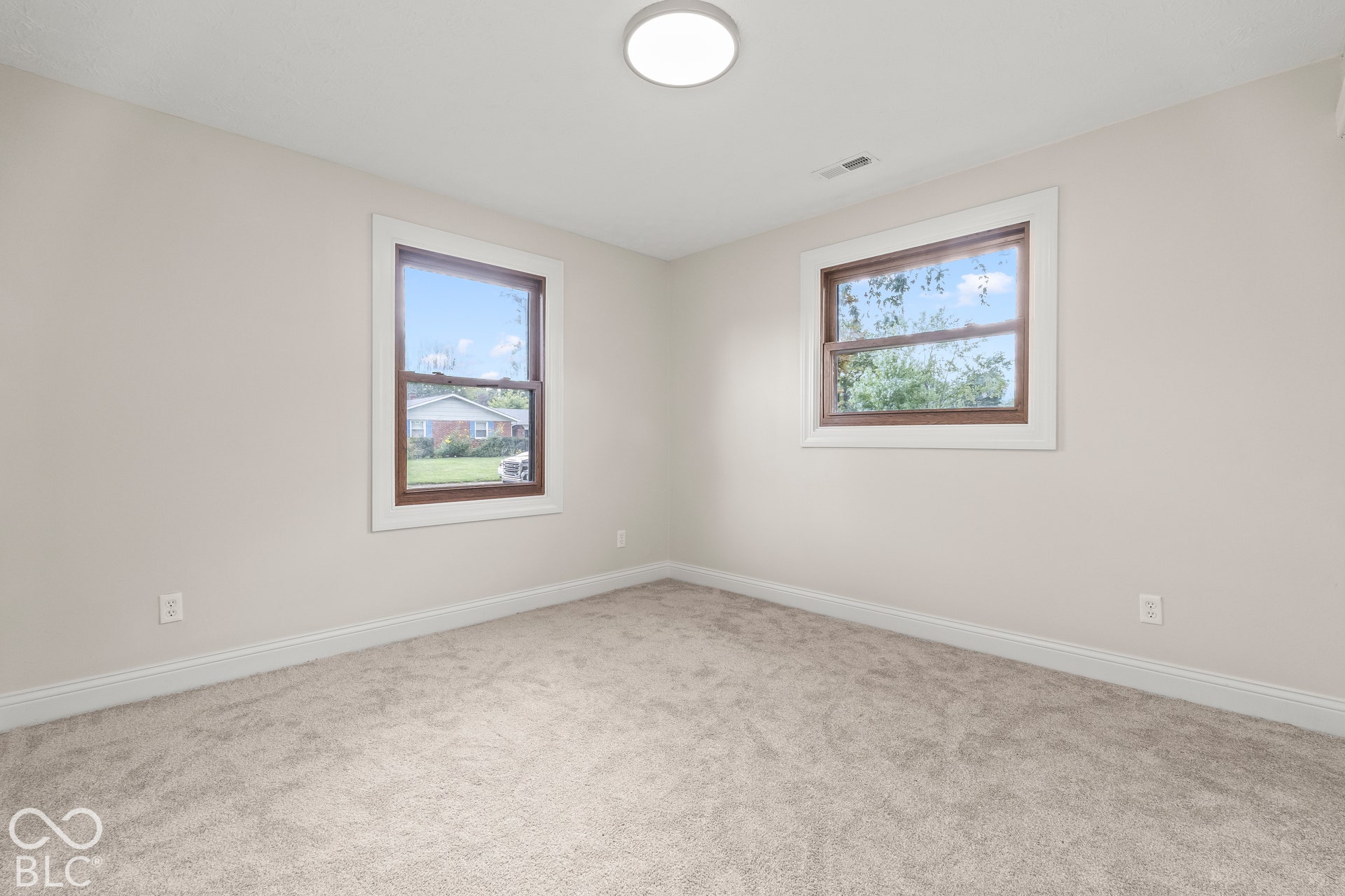 Bedroom 3Carpeted flooring, neutral wall tones, two windows with white trim, and a flush mount ceiling light fixture