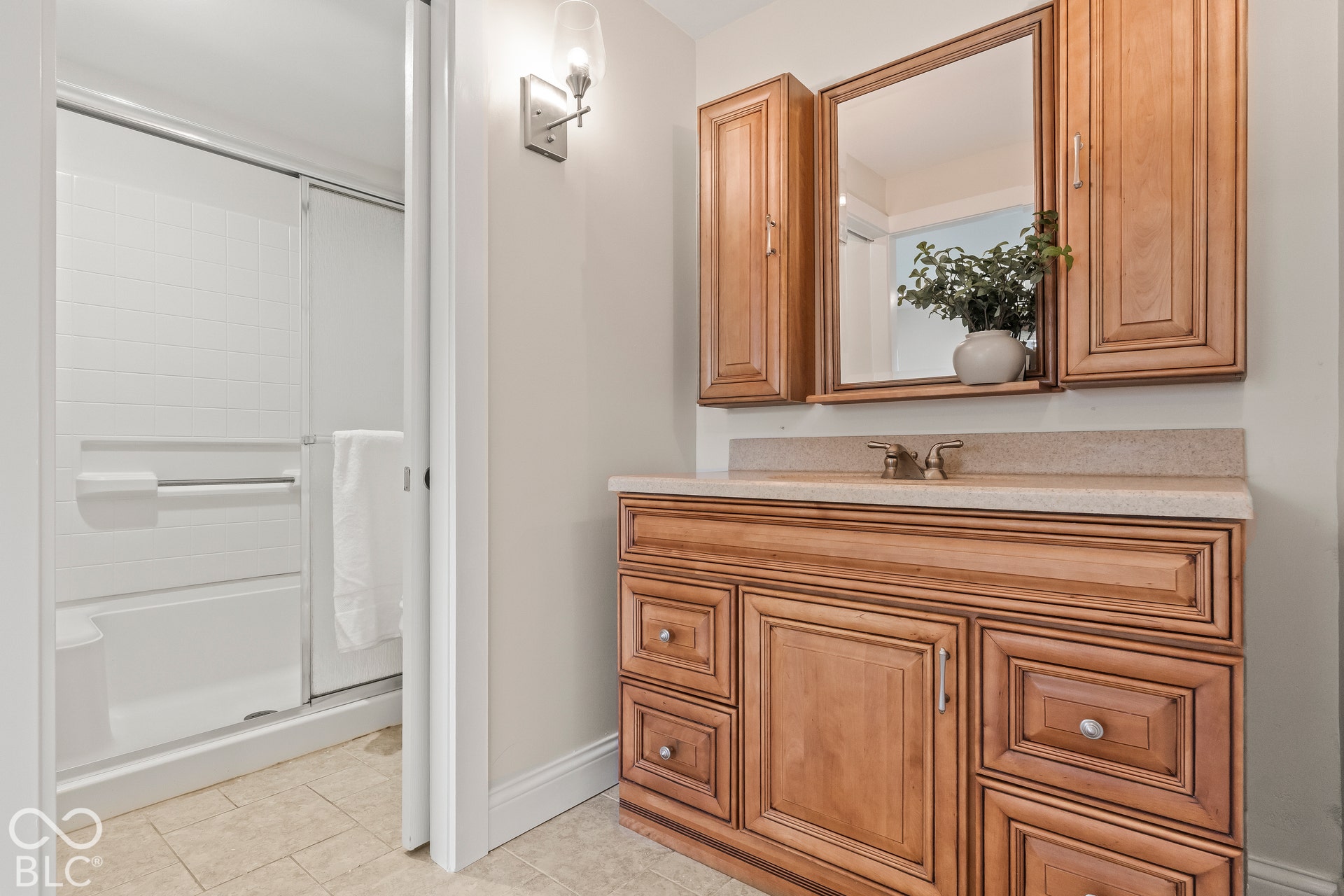 Wood-finish vanity with multiple drawers, stone-finish countertop, and integrated sink