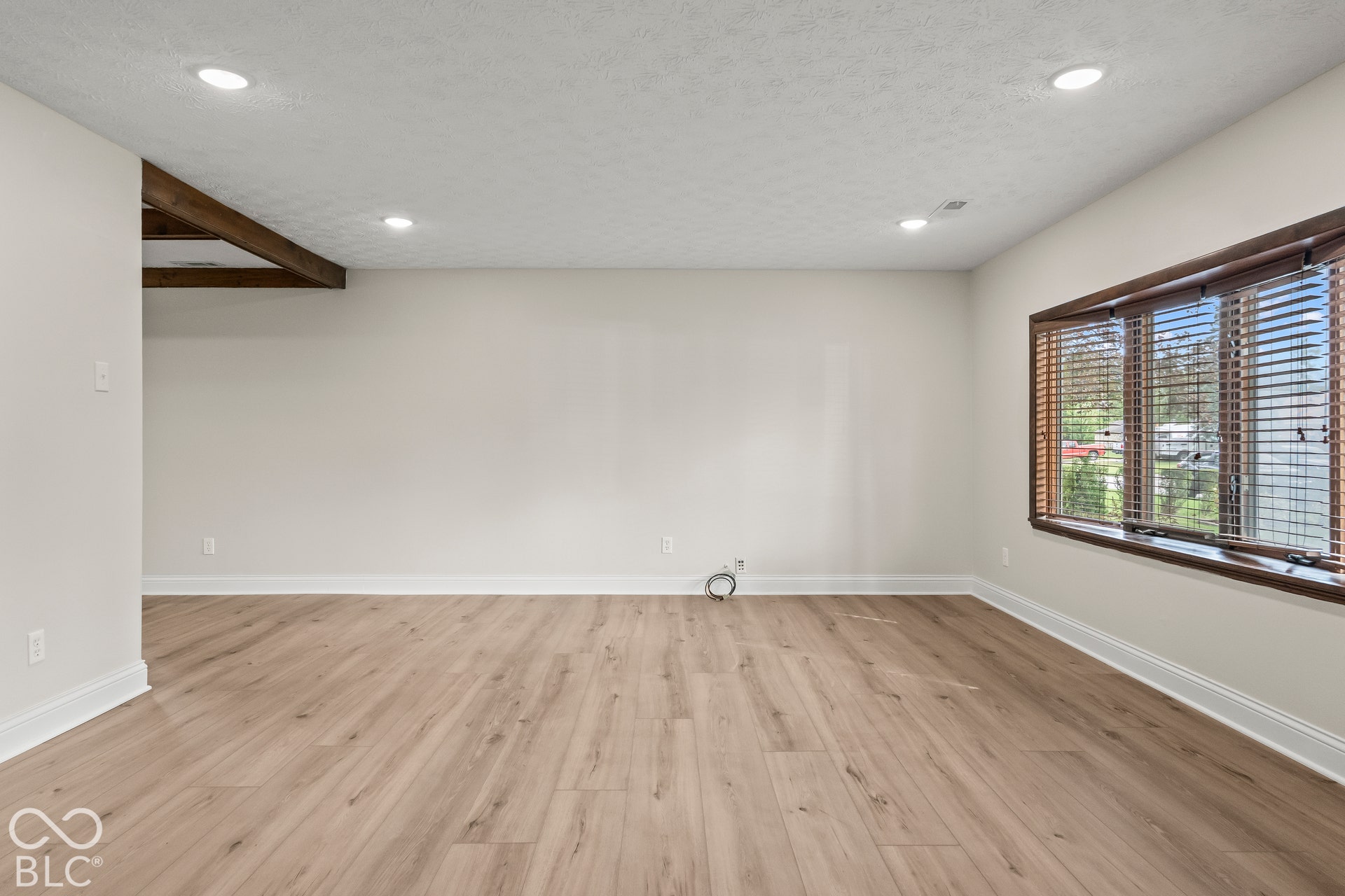 Recessed lighting illuminates wood-finish flooring
