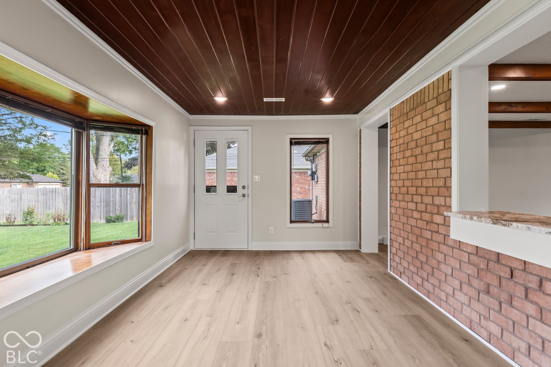Wood-finish flooring with a dark wood panel ceiling