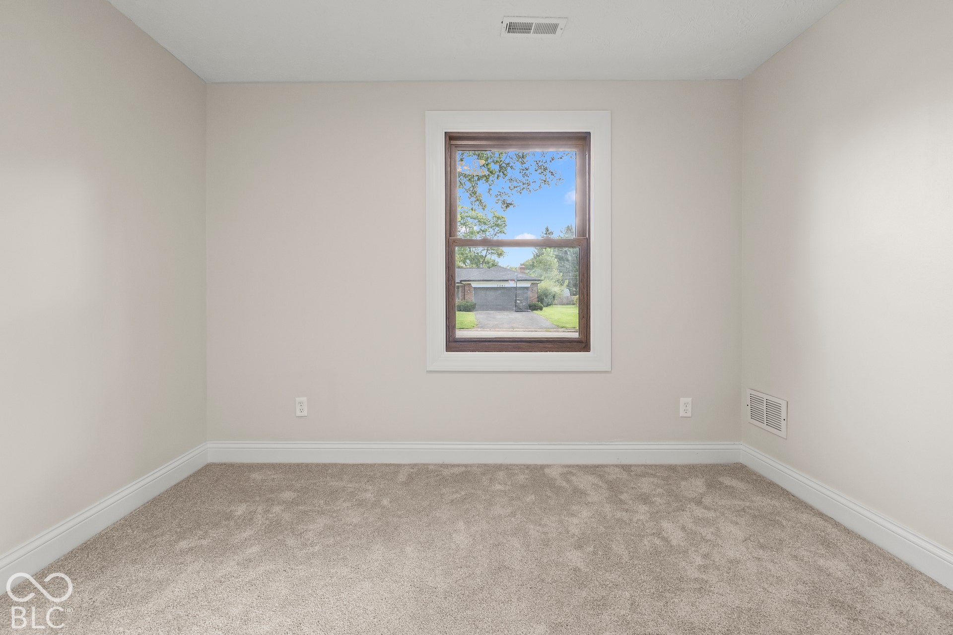 Bedroom 2Neutral paint palette, window with white trim, dark window frame, and gray carpet flooring