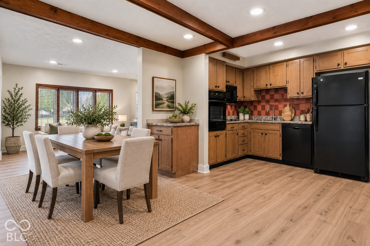Exposed wood ceiling beams, recessed lighting, wood-finish flooring, and a kitchen with wood cabinetry and black appliances