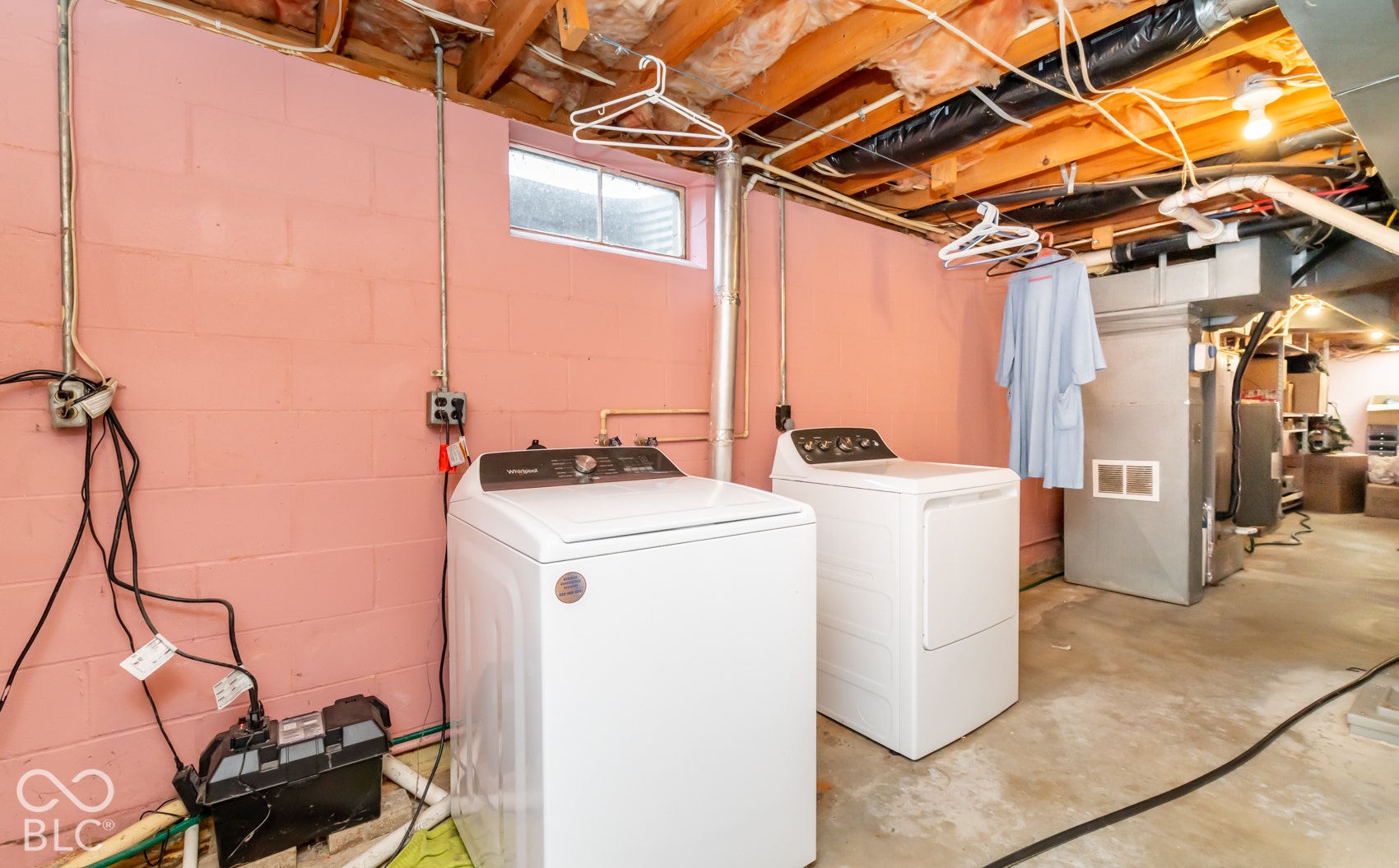 Basement utility space featuring a window, exposed ceiling joists, and concrete flooring