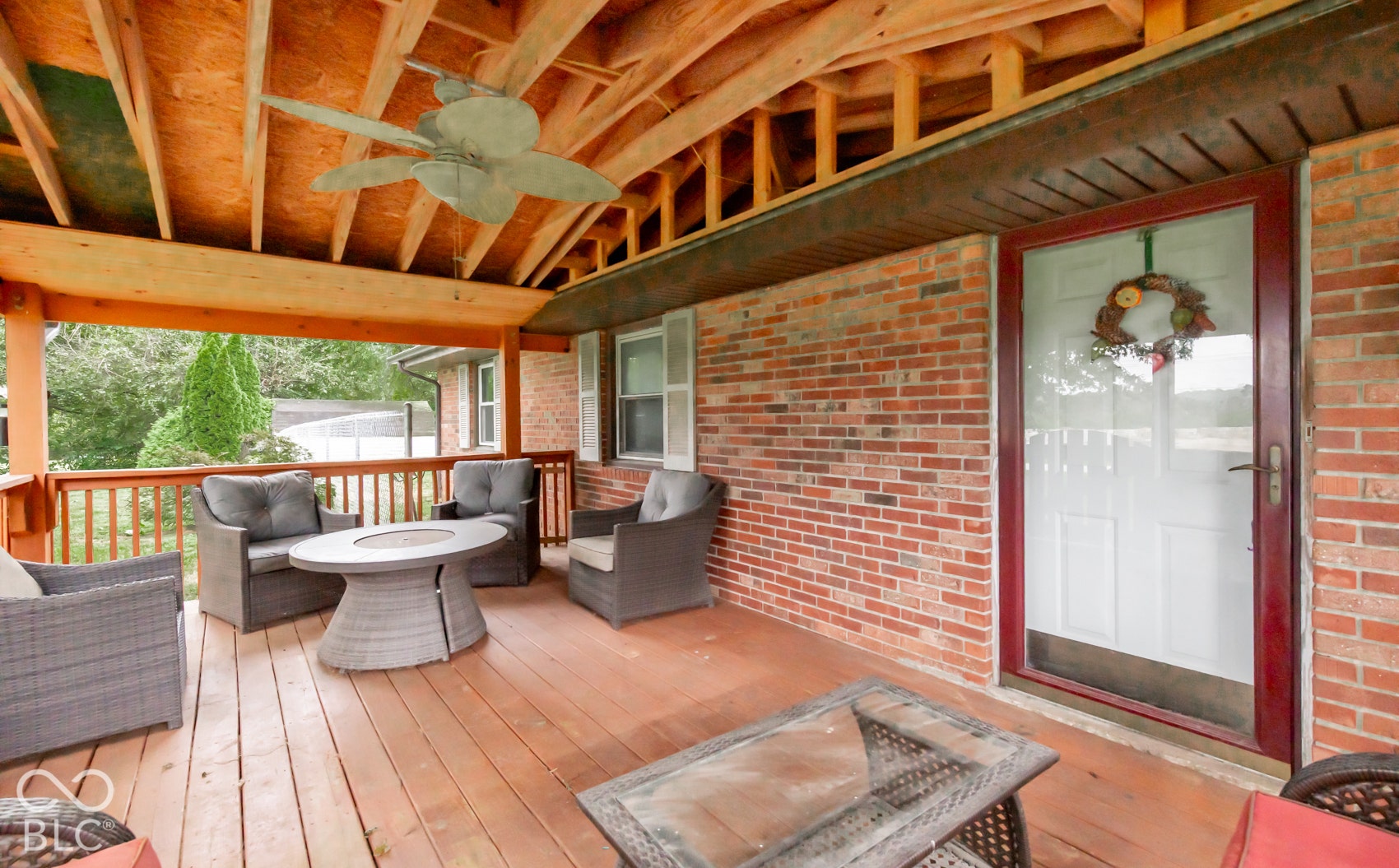 Covered wood deck featuring exposed beam ceiling and ceiling fan