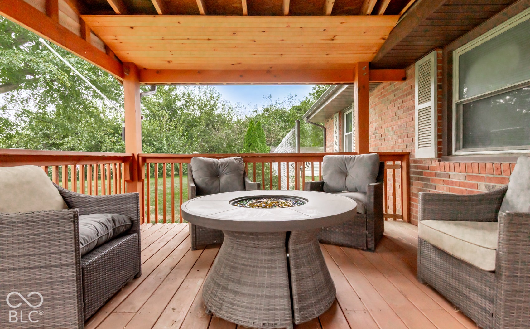 Covered deck with wood-finish flooring, wood railings, and a wood-slatted ceiling