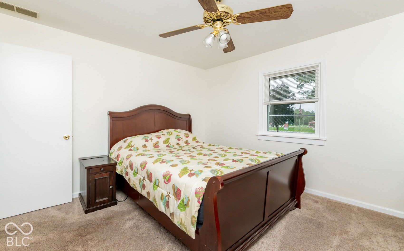 Neutral wall paint, textured carpeting, and a window with blinds