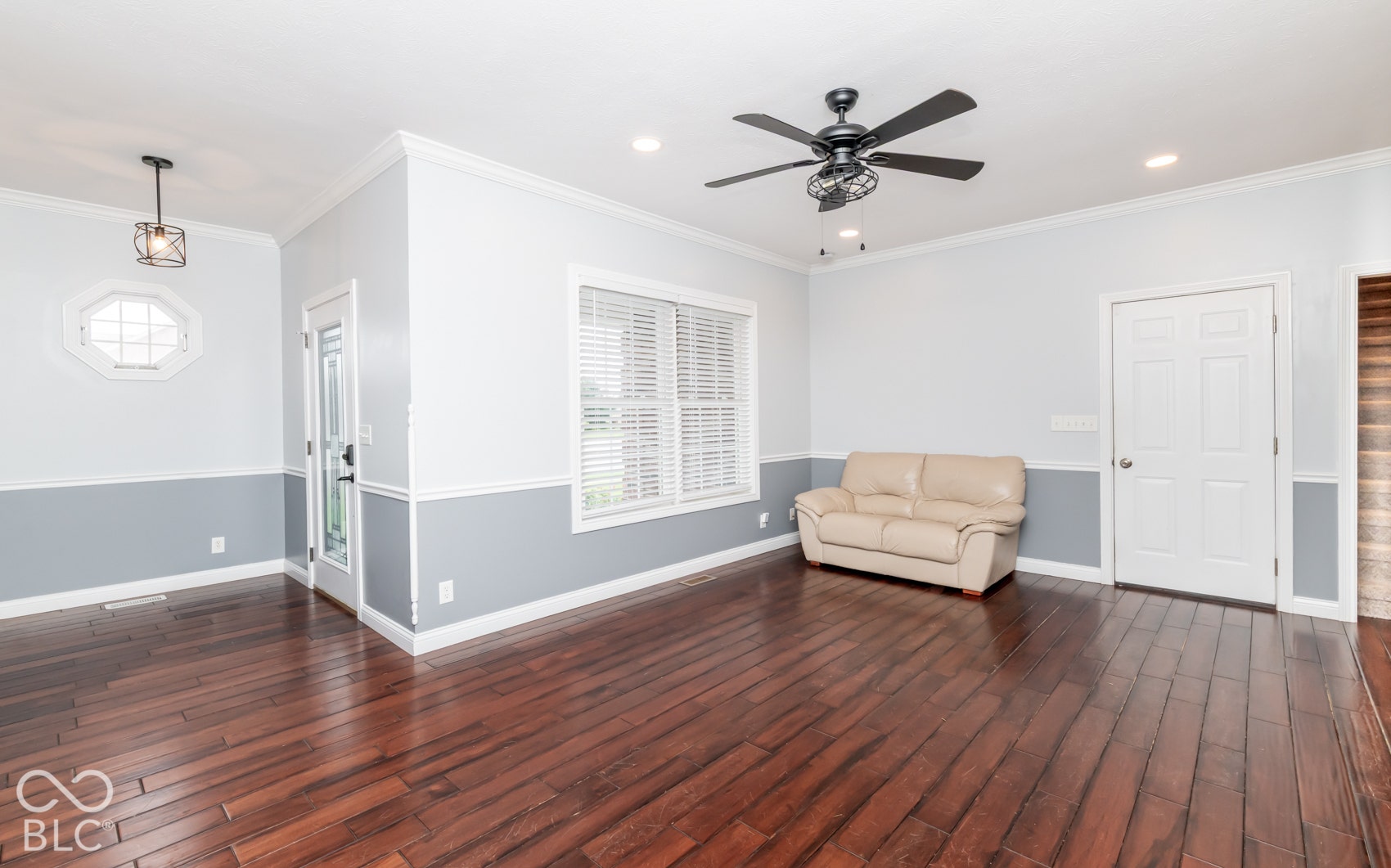 Wood-finish flooring, recessed lighting, crown molding, two-tone painted walls, and a ceiling fan
